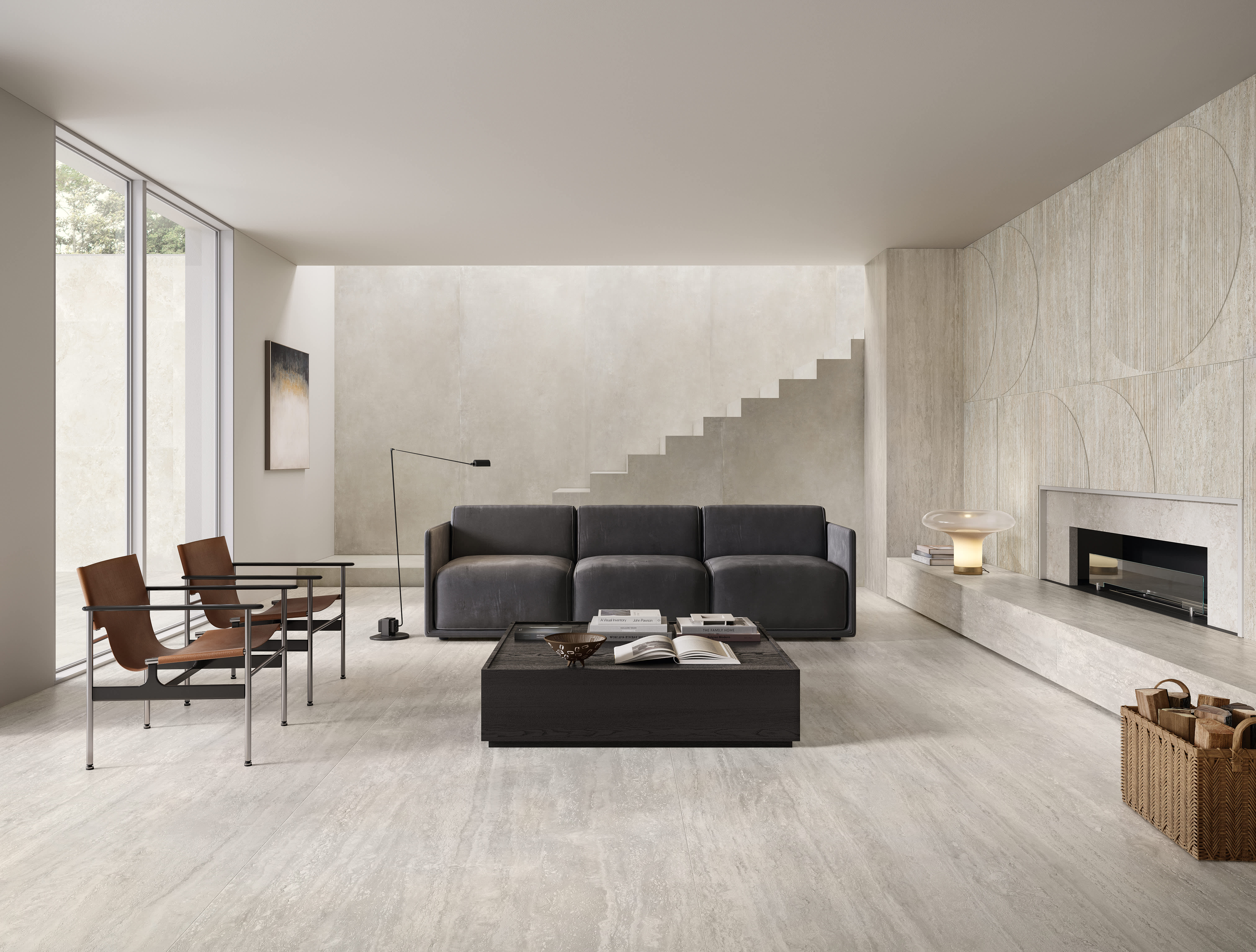 Mega i Travertini porcelain slab in Grigio as flooring and a sculpted fireplace wall in a modern double-height living room with a charcoal sofa and leather sling chairs