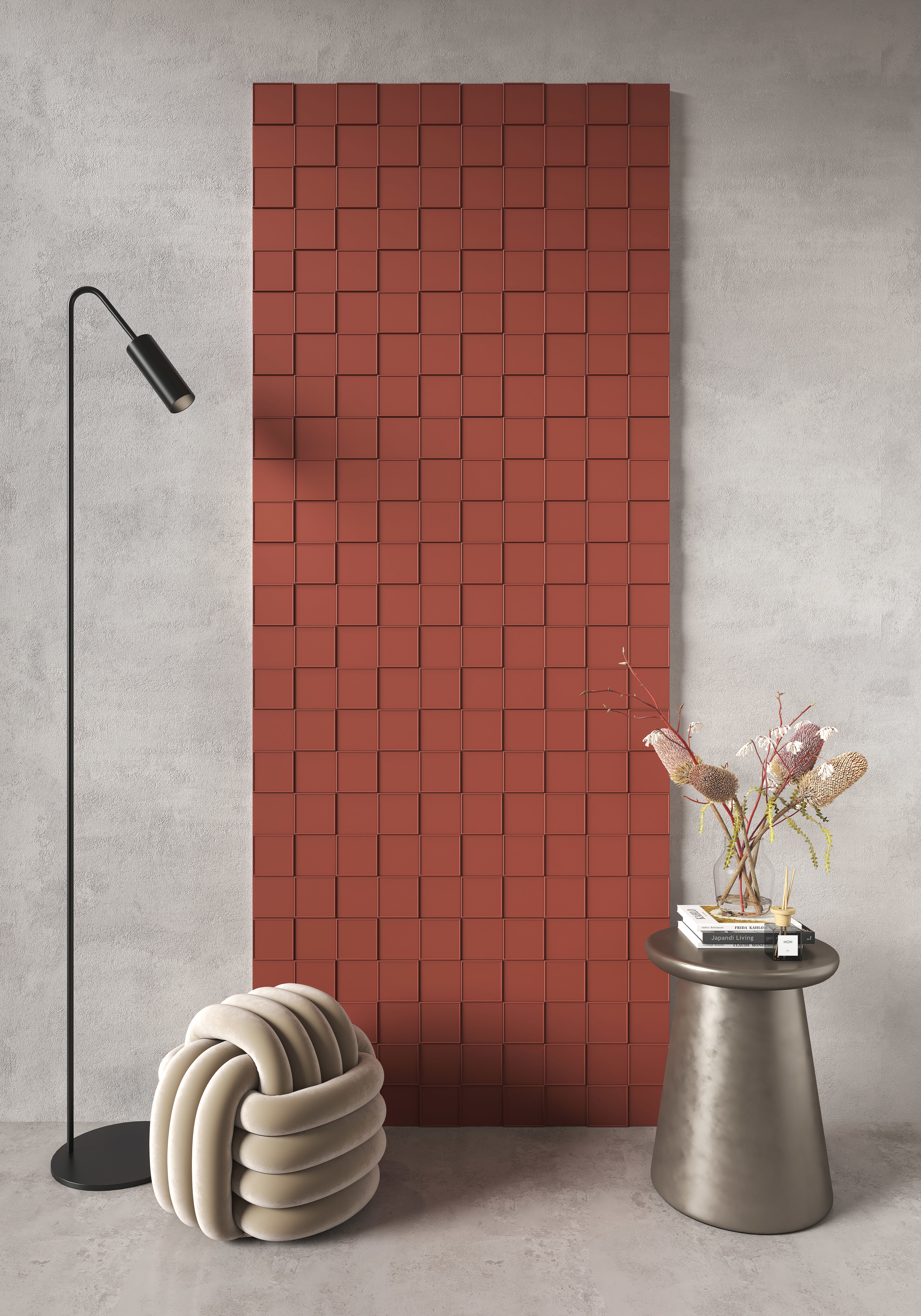 Micro Ways, by Terratinta — a deep brick-red porcelain checkerboard-relief wall panel, paired with a knotted pouf and a slim side table.