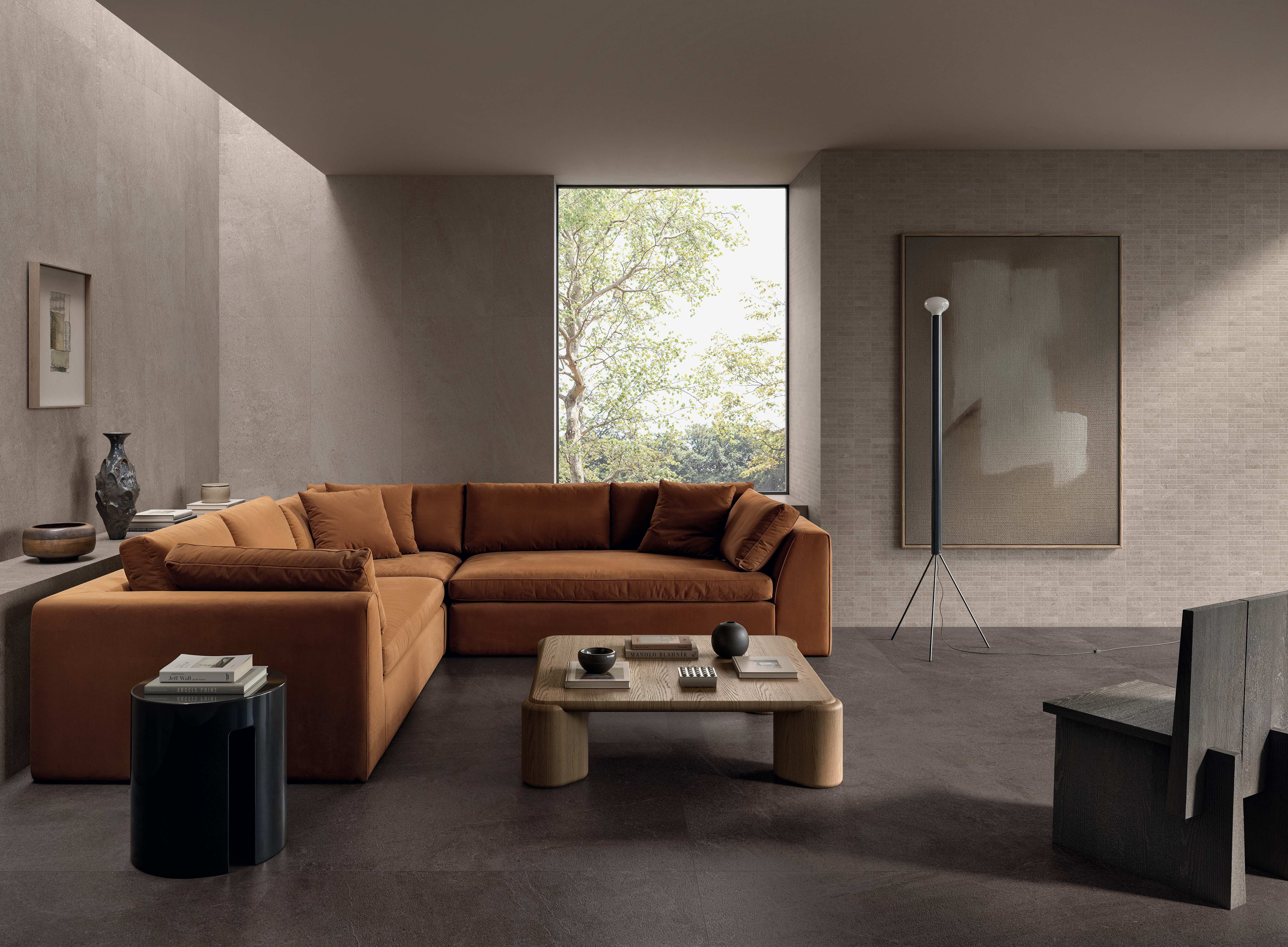 Living room in warm taupe Natural porcelain with a rust sofa and low coffee table.