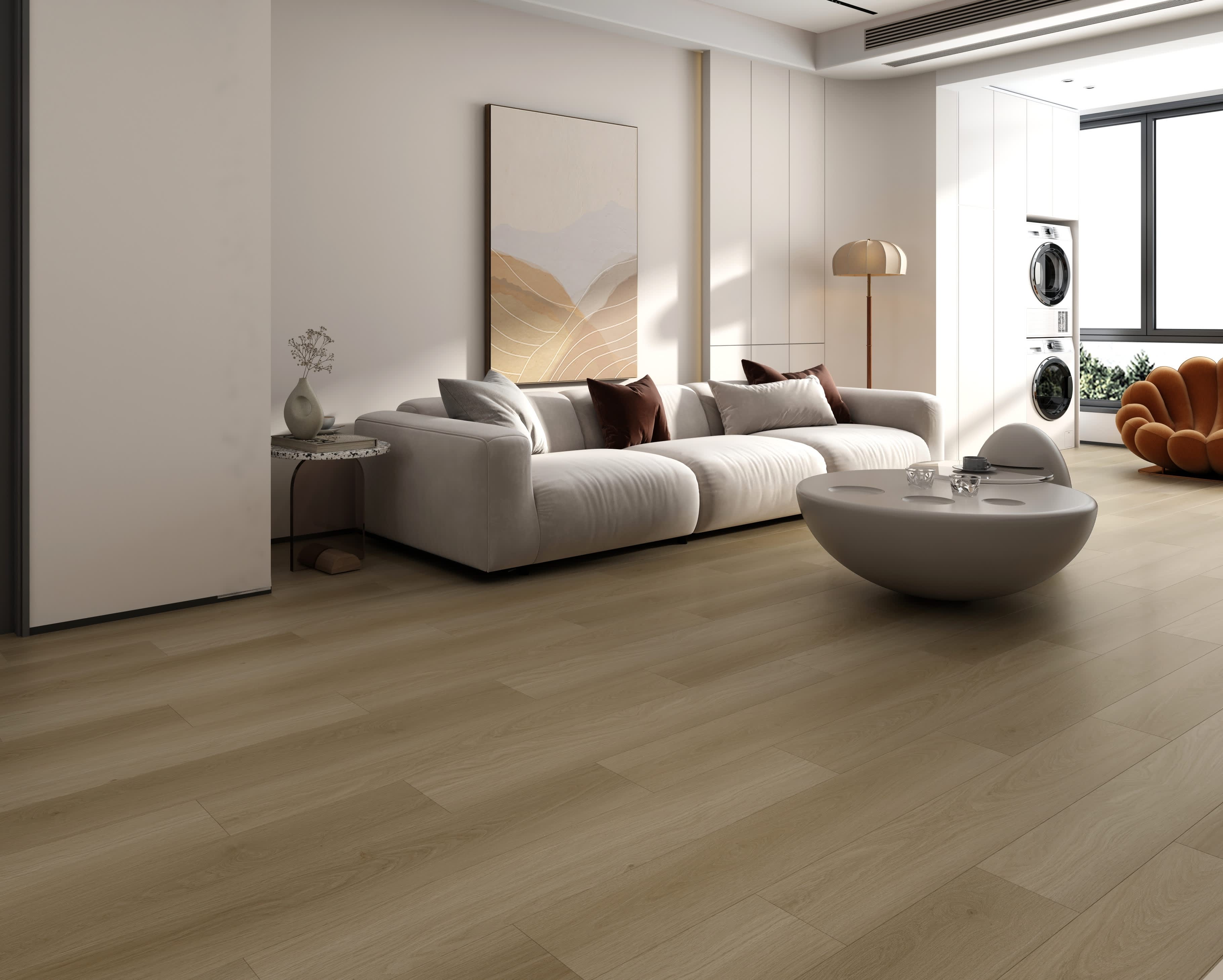 Port vinyl flooring in Drift, honey-taupe wood-look planks in a living room with a white sofa and sculptural coffee table