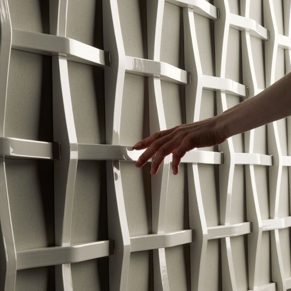 Mutina Adagio sculptural ceramic wall tile close-up showing interwoven white glossy relief and brown accent tiles