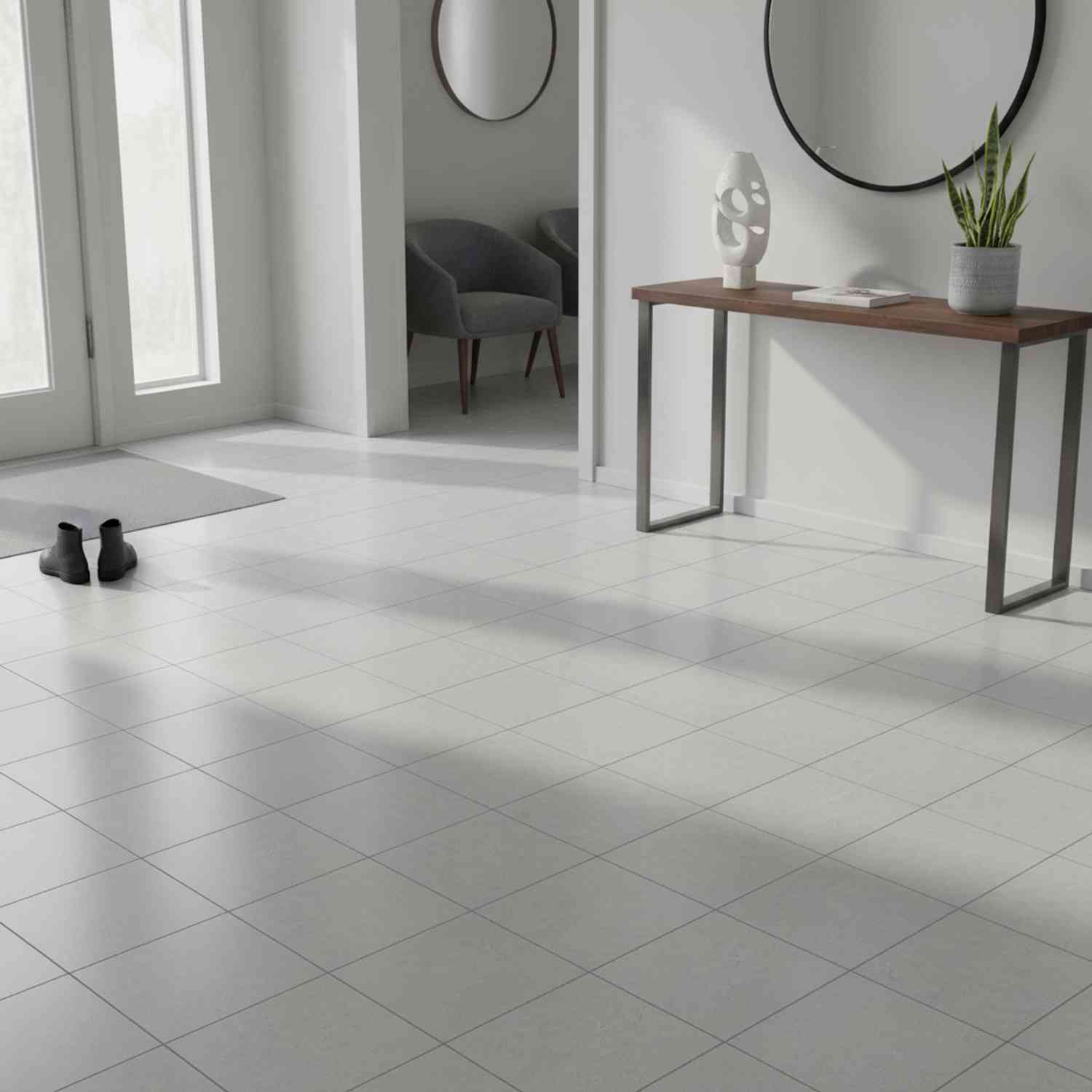 Mutina Aurore Light Grey glazed porcelain stoneware entryway with plain tile floor console table with sculpture round mirror and grey accent chair