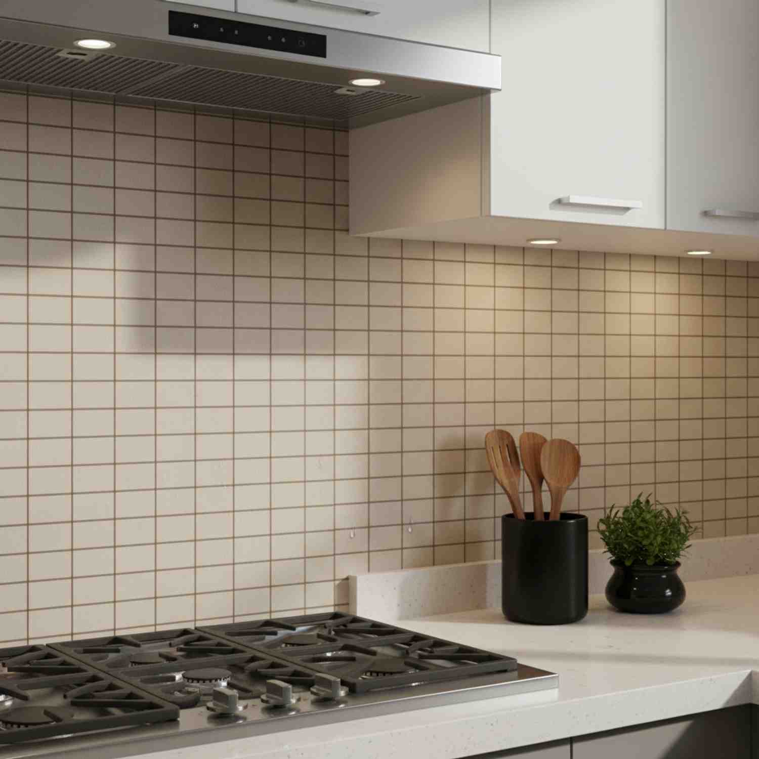Mutina Aurore Light Blue glazed porcelain stoneware kitchen backsplash with grid tile wall stainless steel range hood under-cabinet lighting and wooden cooking utensils