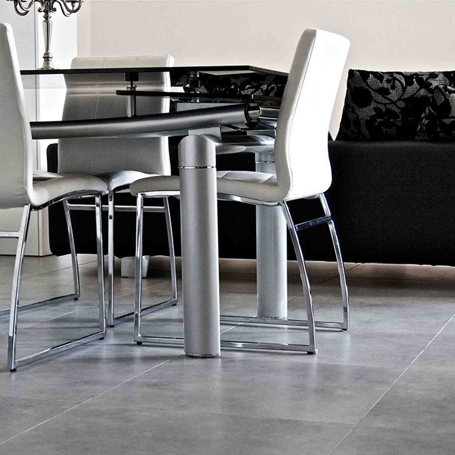 Terratinta Betontech Anthracite full-body porcelain stoneware floor tile close-up in modern dining area with chrome and white leather chairs glass table and dark sofa
