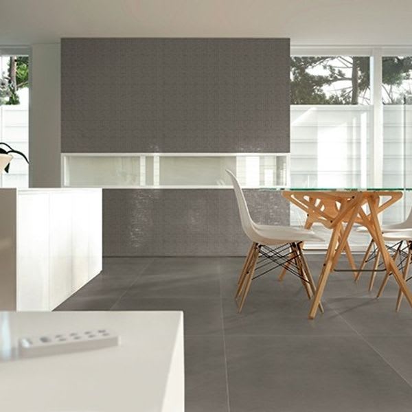 Terratinta Betontech Grey full-body porcelain stoneware floor and wall tile in modern dining room with white Eames chairs wooden table and large windows