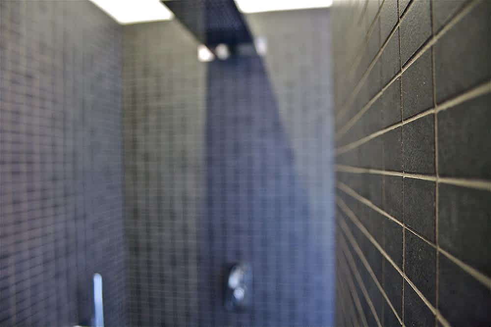Terratinta Betontech mosaic Grey full-body porcelain stoneware rectangular mosaic wall tile in modern shower with glass door and chrome fixtures
