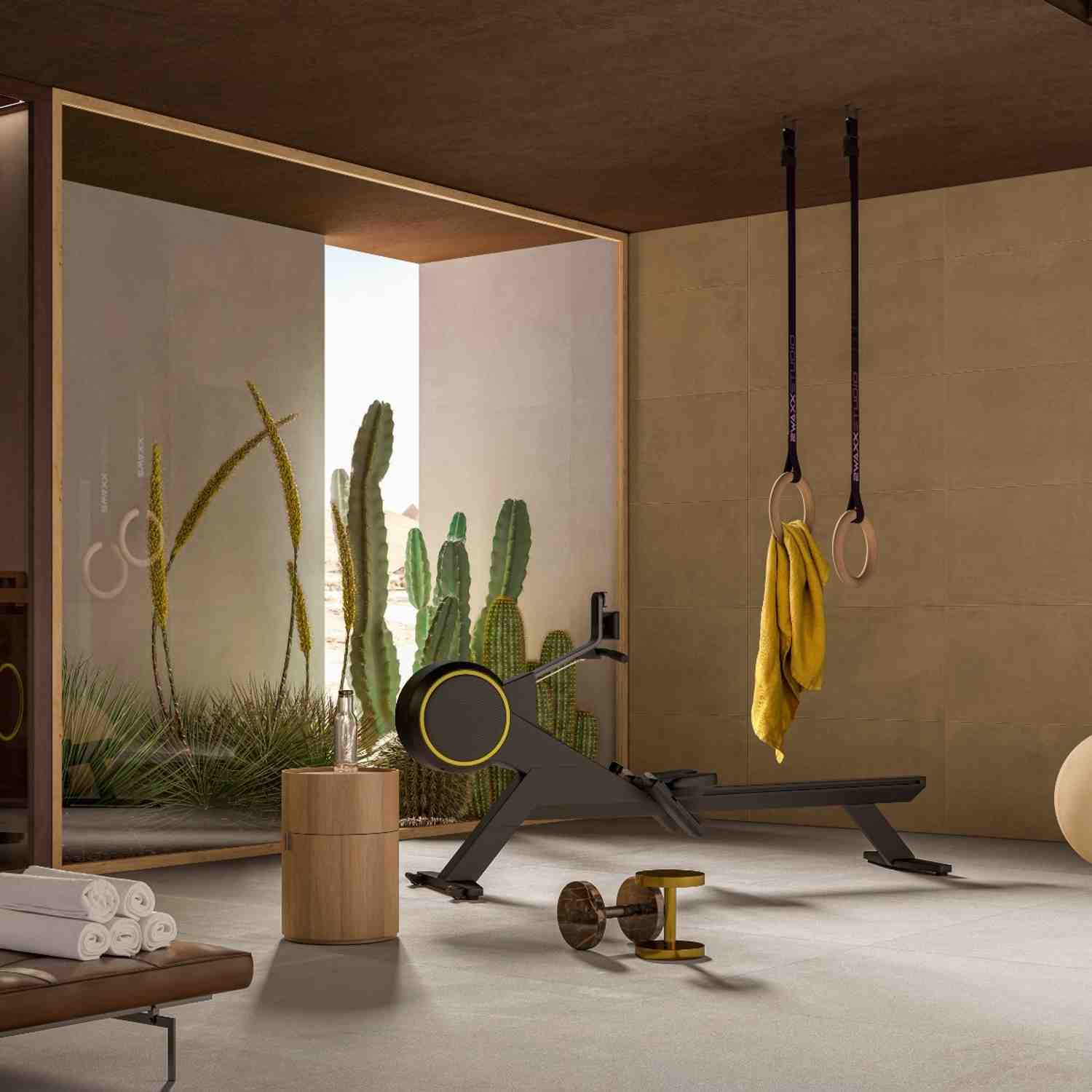 Cementum cement-look porcelain tile in warm brown tone installed as wall and floor tile in a modern home gym with gymnastics rings and cacti