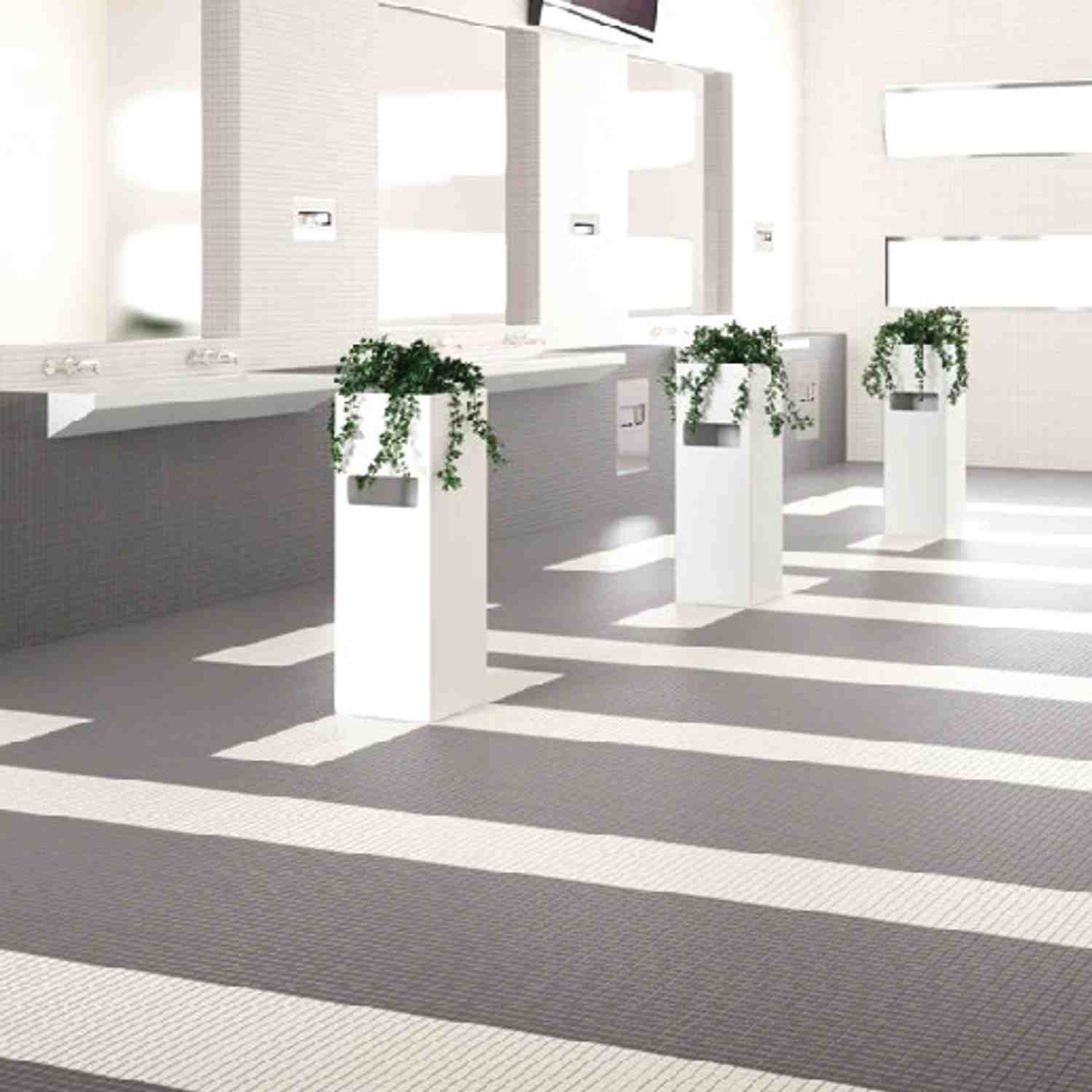 Cesi glazed porcelain stoneware floor tiles in white and grey geometric pattern in modern commercial washroom with grey vanity counter wall-mounted faucets white pedestal planters with trailing greenery and bright natural light