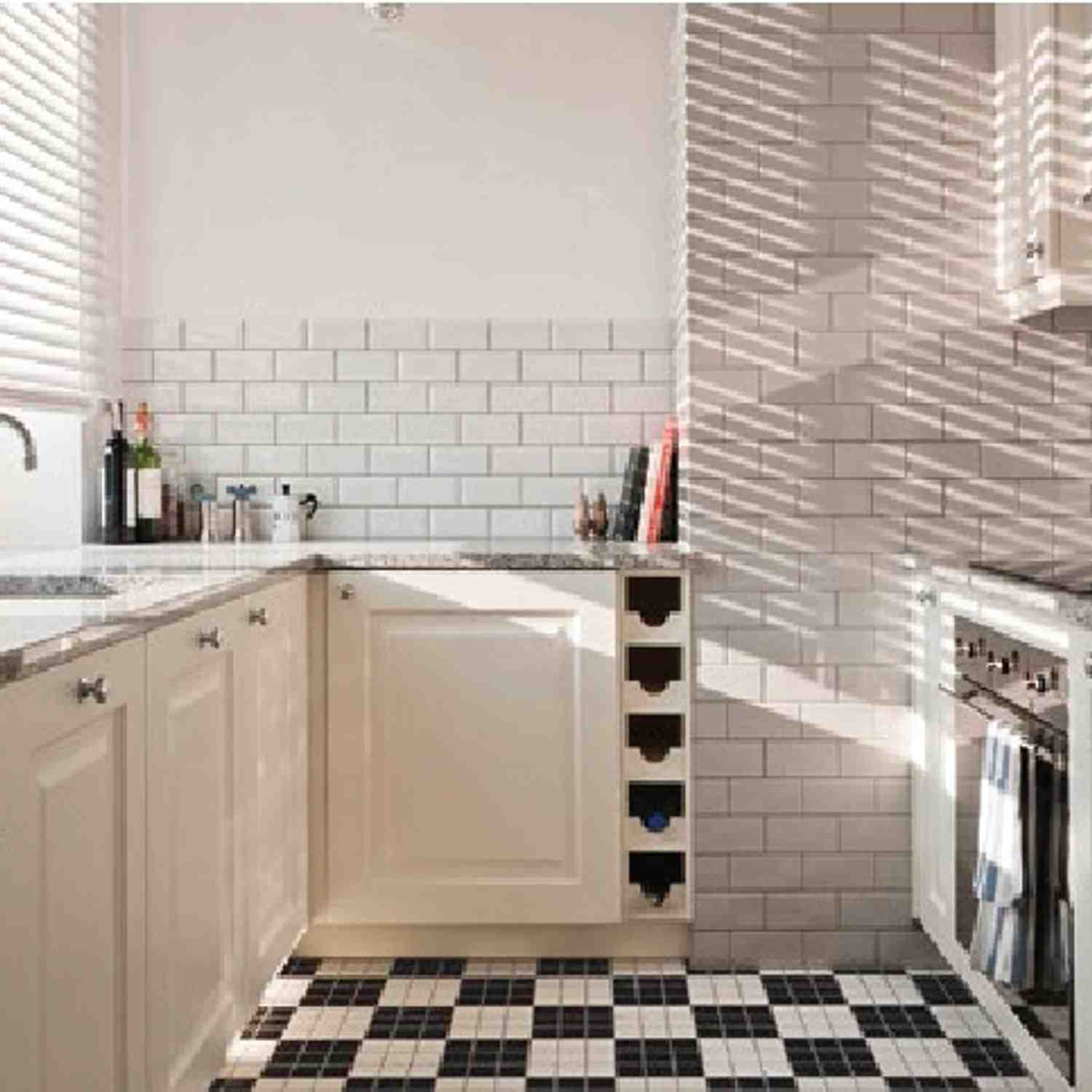 Cesi glazed porcelain stoneware wall tiles in white subway brick pattern installed as kitchen backsplash with white shaker cabinets dark hardware speckled granite countertops and natural light