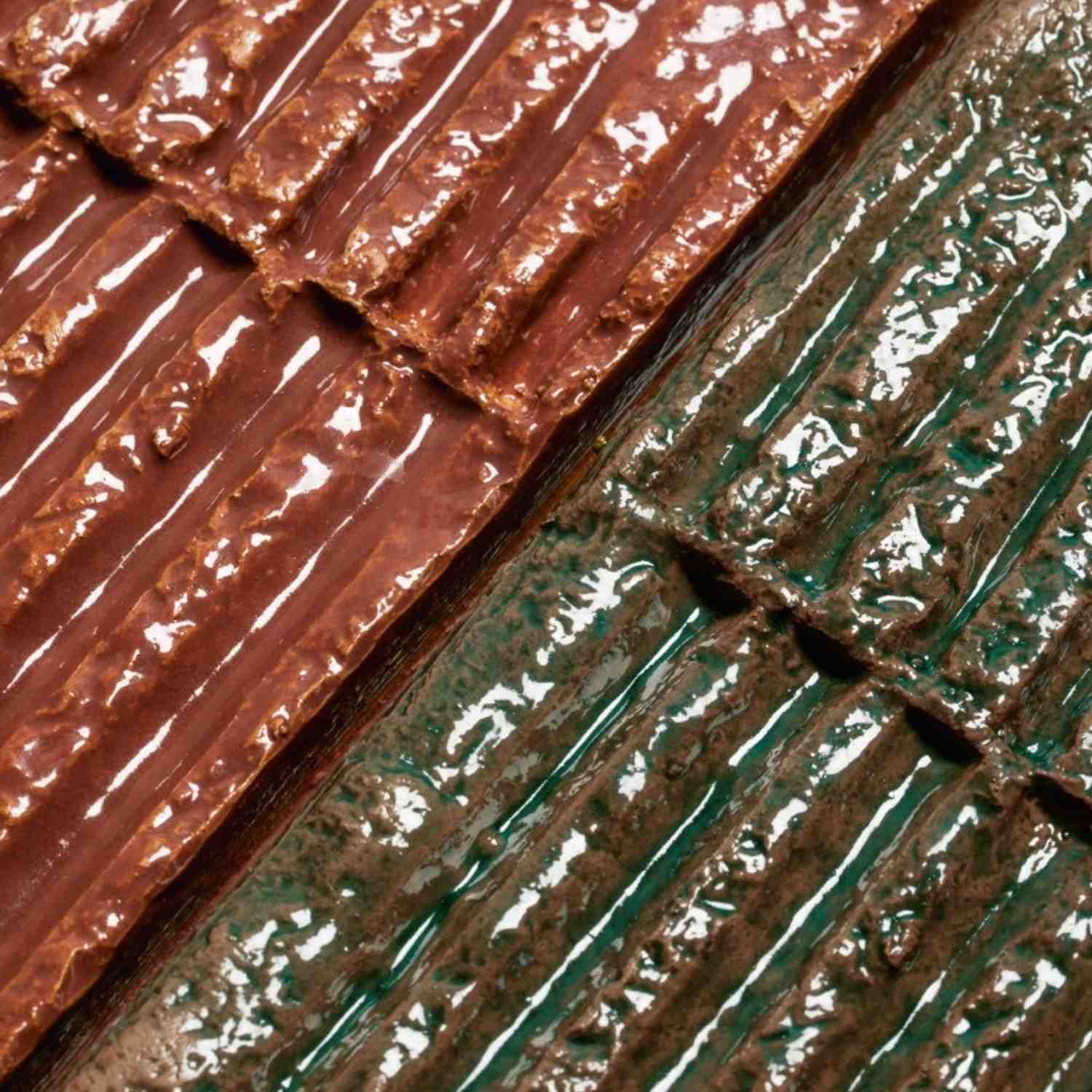Mutina Chamotte high-gloss glazed ceramic wall tiles close-up showing Terra brown and Verde green colors with pronounced tactile texture irregular surface relief and artistic glaze finish