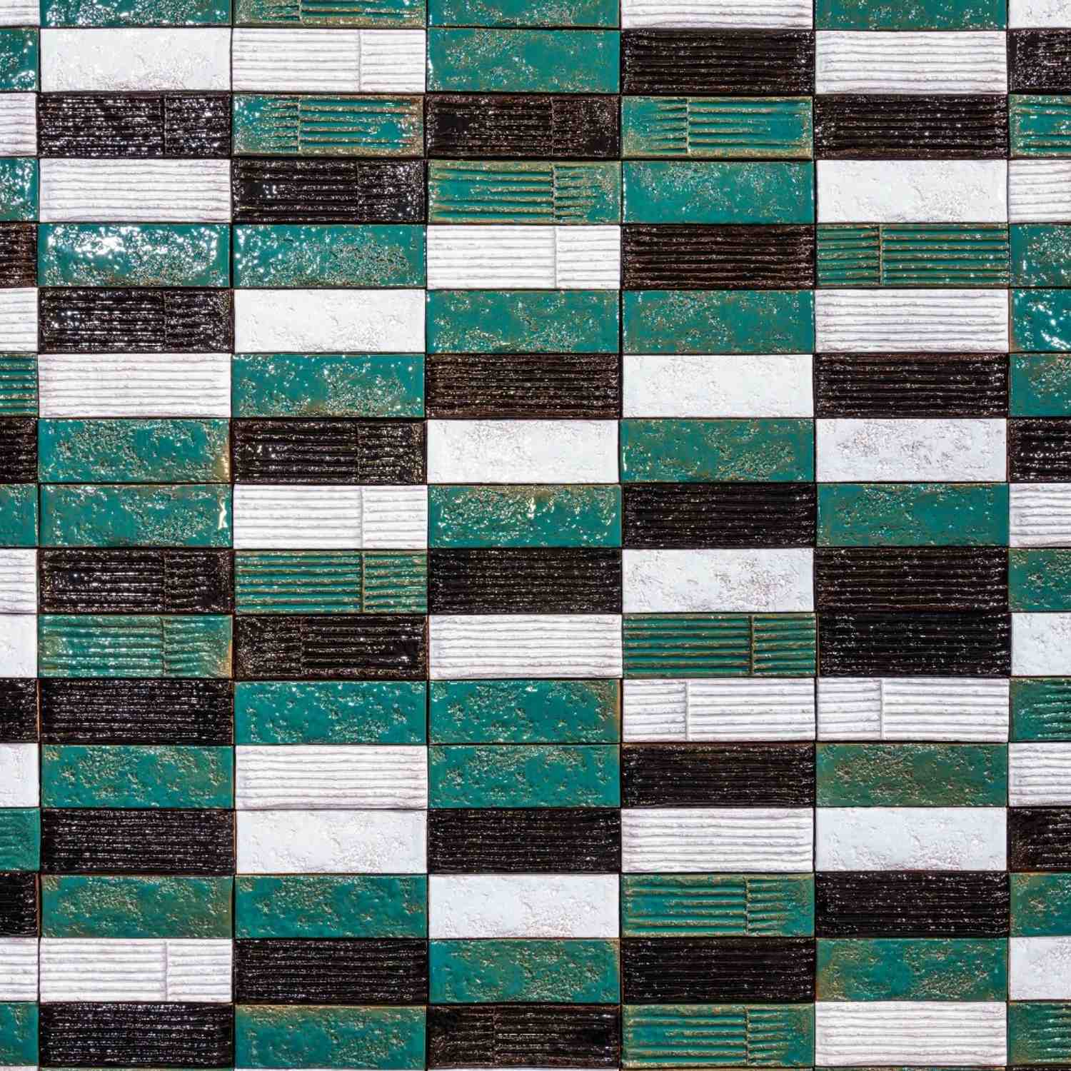 Mutina Chamotte Quadra high-gloss glazed ceramic wall tiles installed in patchwork pattern mixing Verde teal-green Nero dark and Bianco white colors with Linea and Mono texture variations