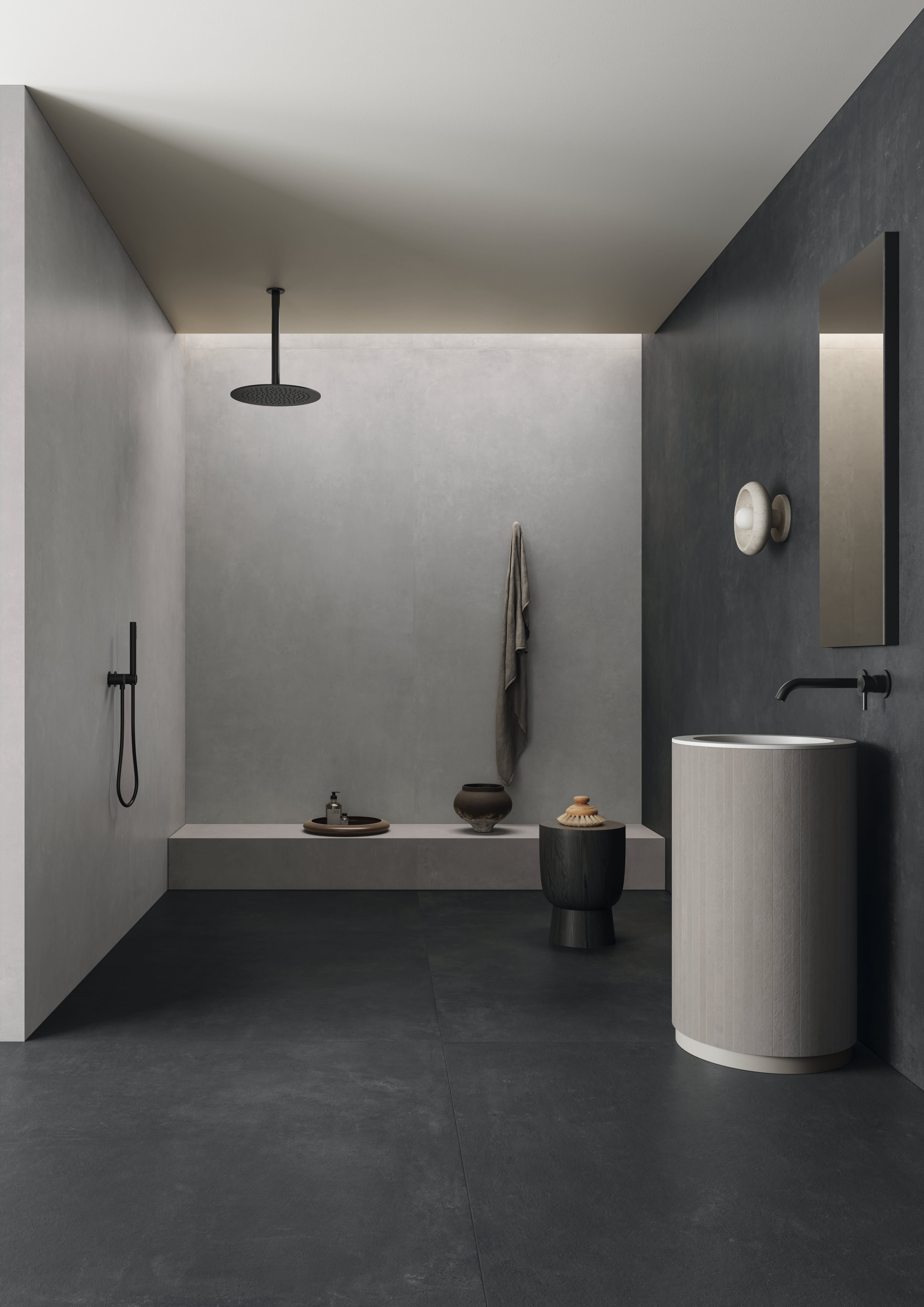 Concrete porcelain tile in a dark charcoal bathroom, large-format floor and walls with a walk-in rain shower, a freestanding pedestal basin and a wall niche.