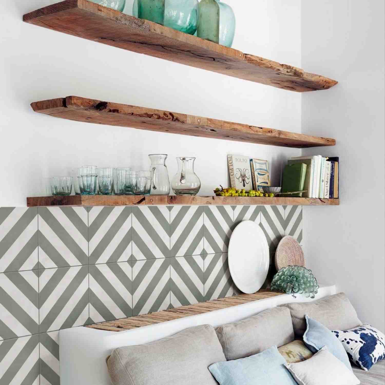 Marazzi Contrasti glazed porcelain stoneware decorative wall tiles close-up in grey and white geometric chevron Tappeto pattern with rustic reclaimed wooden floating shelves displaying green glass vases glassware books and decorative objects