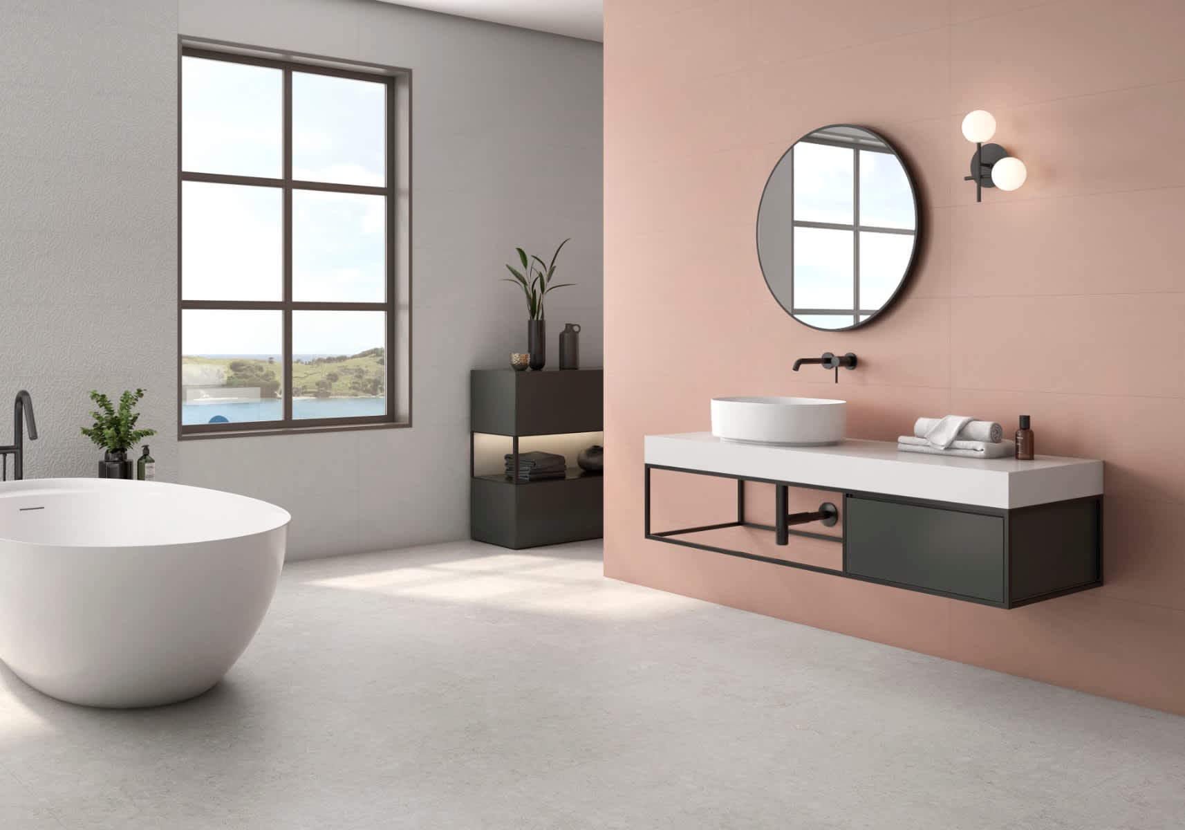 Pamesa Coralstone porcelain stoneware mosaic wall tiles in warm pink coral stone finish installed in modern bathroom with large round black-framed mirror dark green floating vanity white countertop white vessel sink black wall-mounted faucet globe wall sc