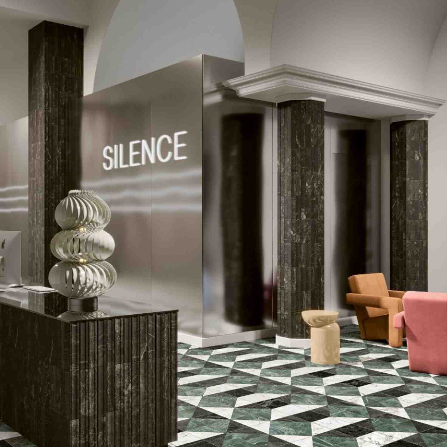 41zero42 Dandy glazed porcelain stoneware dark green black marble-look vertical strip tiles on columns in luxury hotel lobby with SILENCE neon sign decorative metallic ribbed vases arched doorways classical molding and colorful modern armchairs