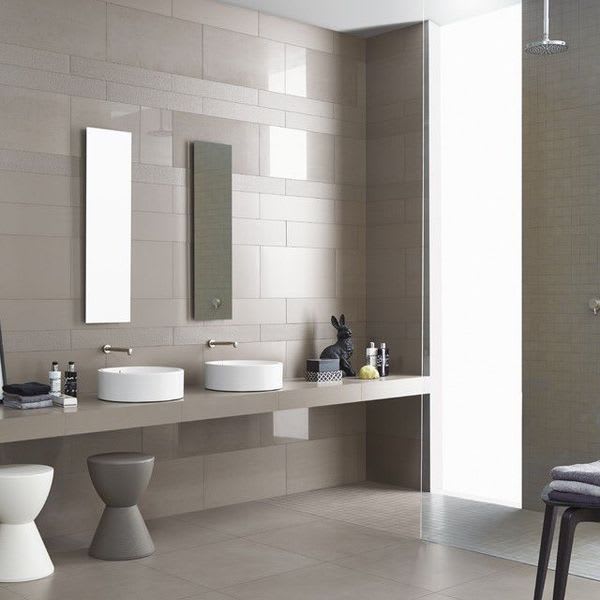 Cream porcelain stoneware wall and floor tile in modern bathroom with double vanity