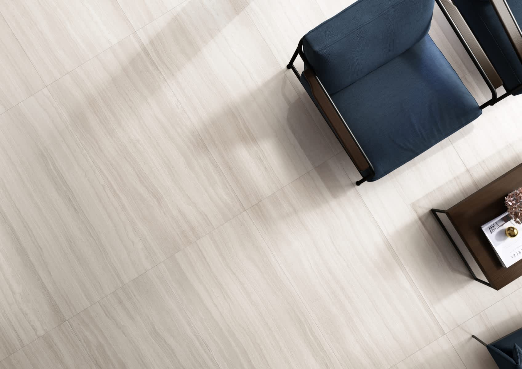 Coem Flow mosaic porcelain stoneware large format floor tiles in ivory cream with subtle linear grain shown from above in modern living space with dark teal armchairs dark wood side table and books