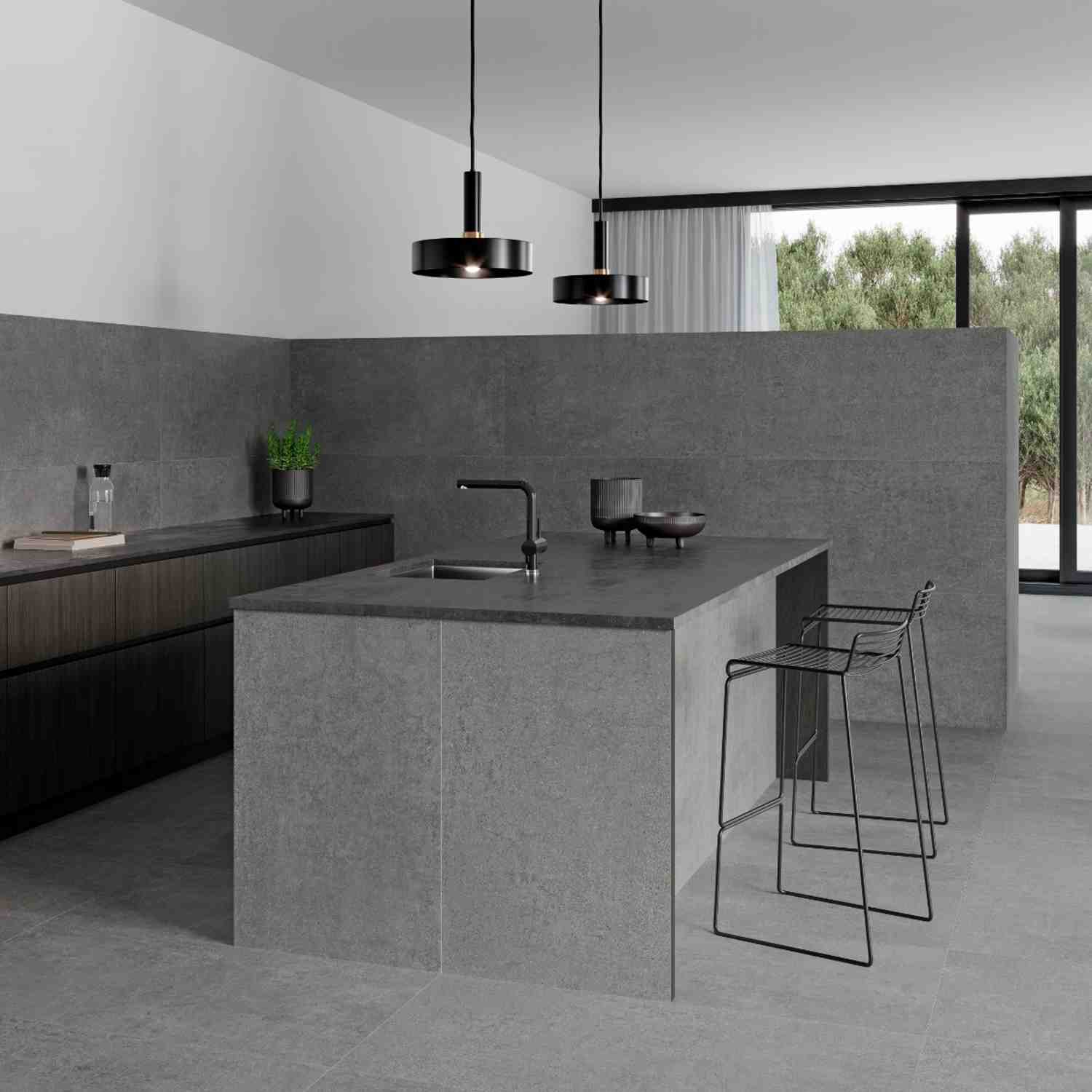 Argenta Gravel porcelain stoneware wall cladding and countertop in grey with stone-cement matte finish in modern kitchen featuring black pendant lights wire bar stools kitchen island and floor-to-ceiling windows