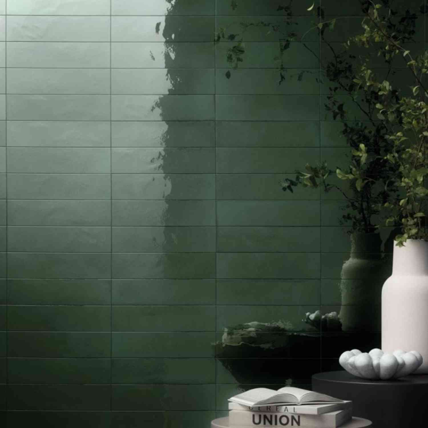 Refin Halo porcelain wall tiles in ocean gloss lustre finish with deep teal green tone featuring 6x24 format brick-lay pattern with white ceramic vase trailing greenery and subtle light reflections on glossy surface