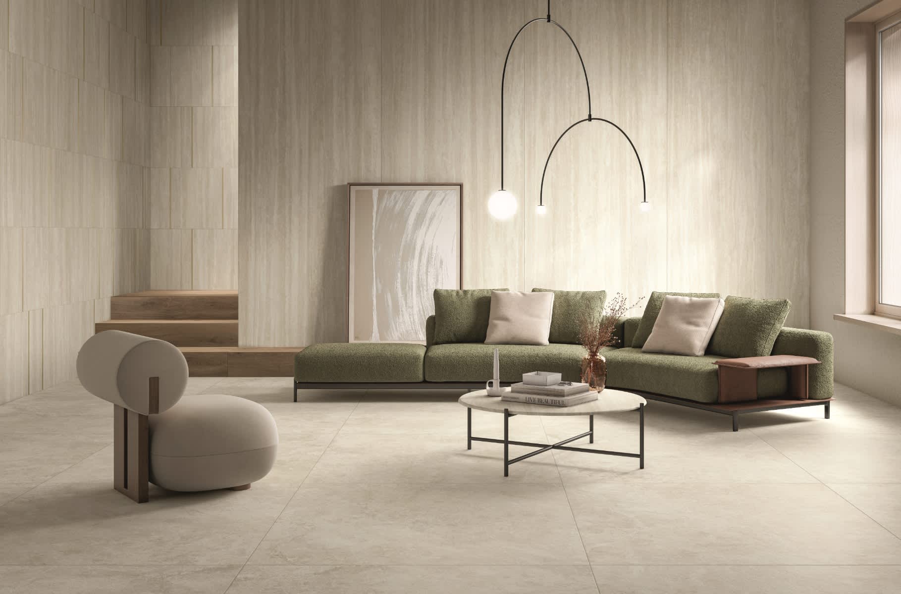 Caesar Iconica mosaic porcelain tile with warm beige wood-grain wall cladding and large format floor tiles in modern living room with green velvet sectional sofa arc floor lamp abstract artwork marble coffee table and sculptural armchair