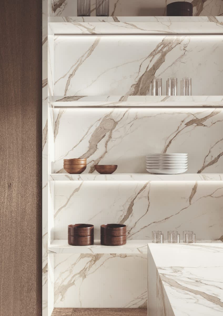 Italstone porcelain slab in Calacatta Supremo, lining kitchen shelving with broad amber-gold veining on white.