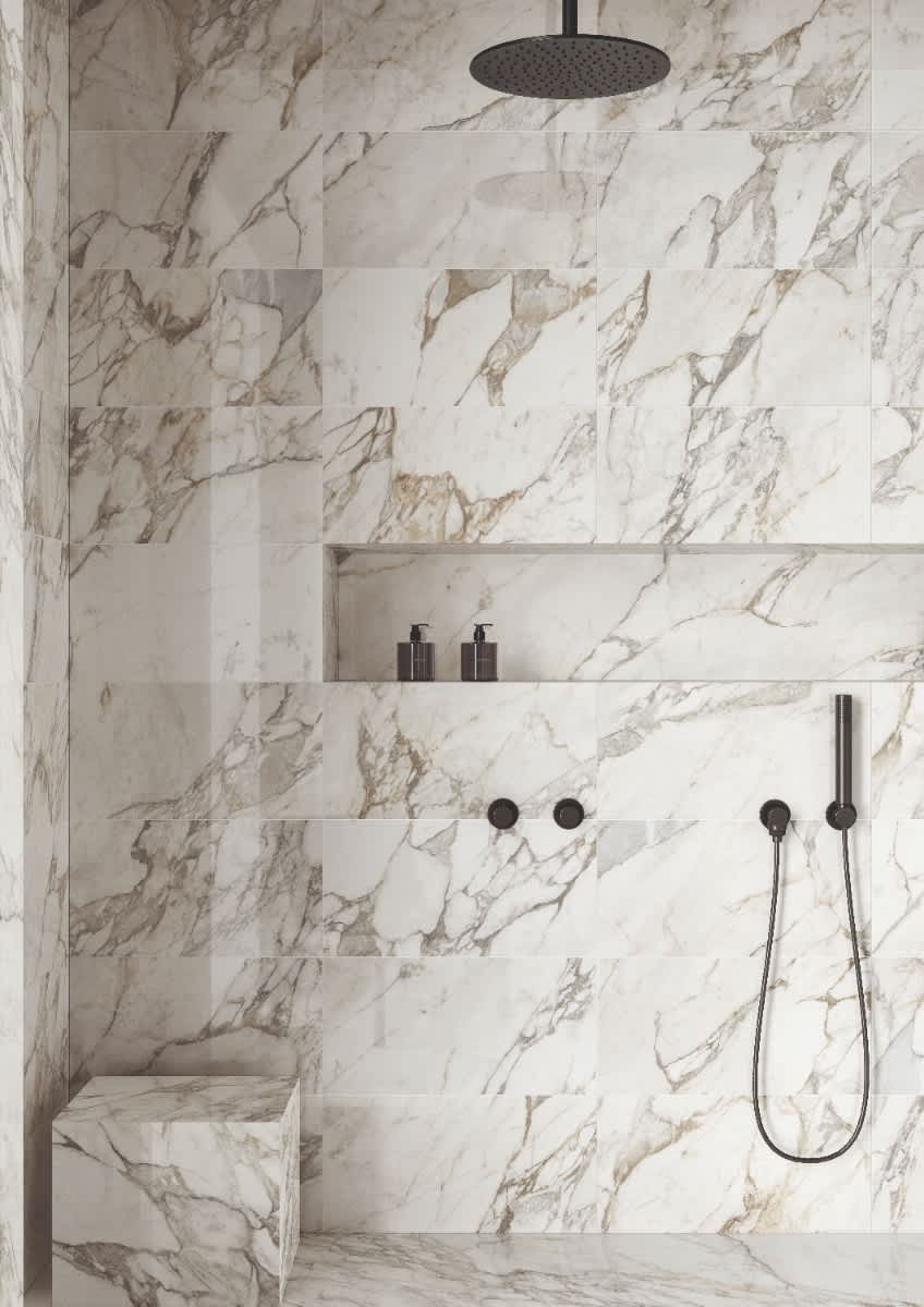 Italstone porcelain slab in Calacatta Vagli, installed across a walk-in shower with soft grey veining on white.