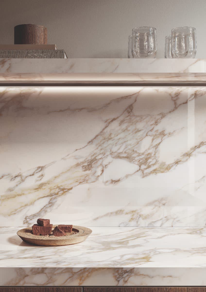 Italstone porcelain slab in Calacatta Gold, installed as a kitchen counter and shelf with warm golden veining on white.