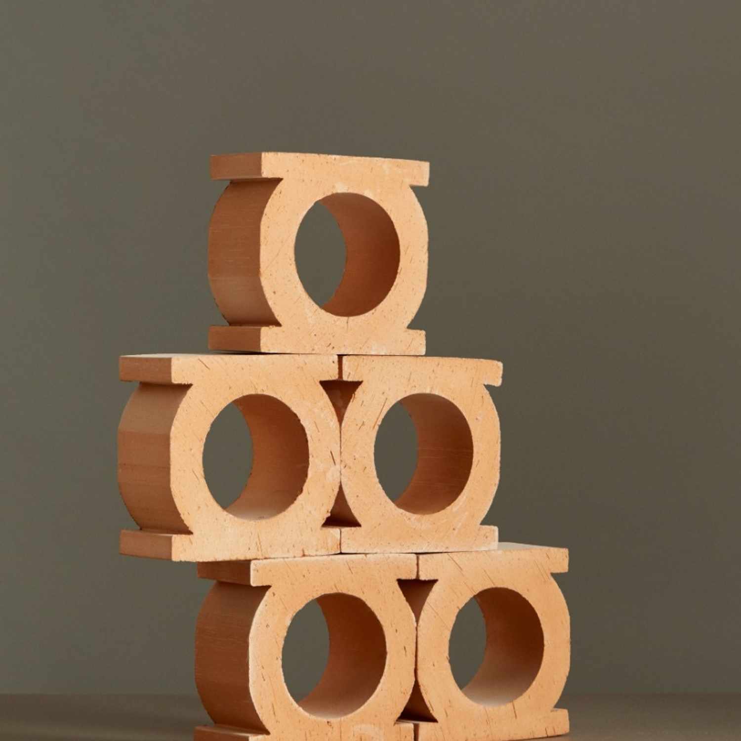 Mutina Jali 3D individual extruded terracotta blocks in bianco finish stacked to show circular and rectangular opening designs against dark background