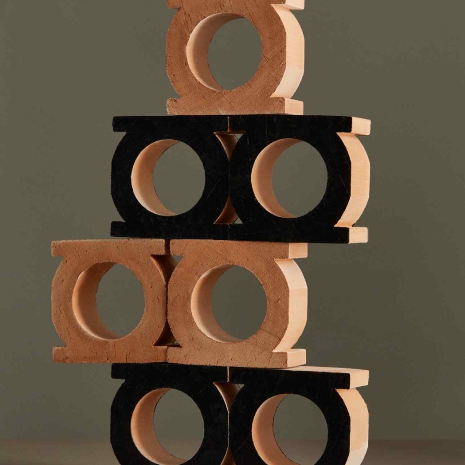 Mutina Jali 3D extruded terracotta blocks in nero black finish with circular and rectangular openings stacked with bianco and neutro pieces showing all three color options