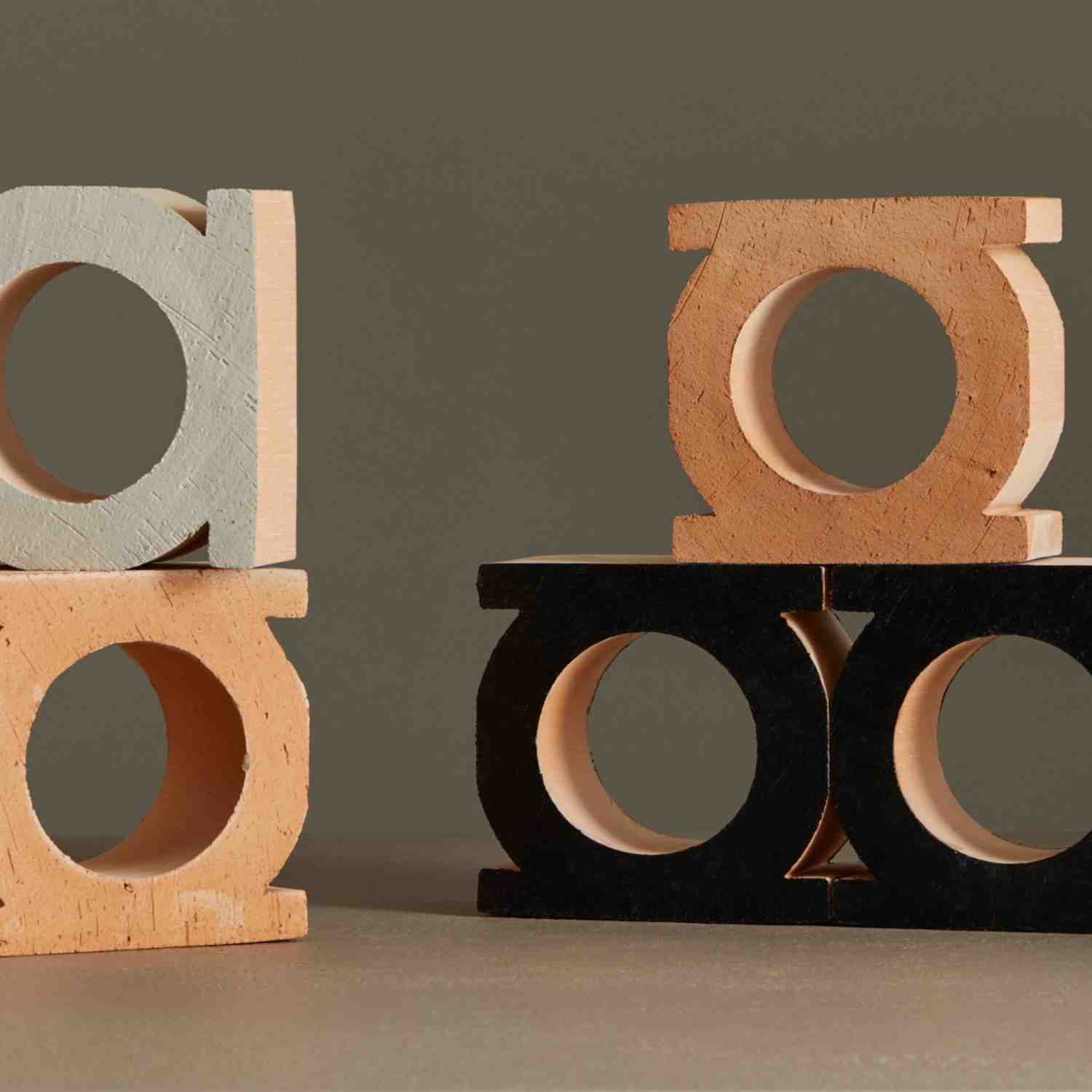 Mutina Jali 3D artisanal extruded terracotta blocks close-up arrangement showing bianco white neutro natural and nero black color variations with circular and rectangular opening designs