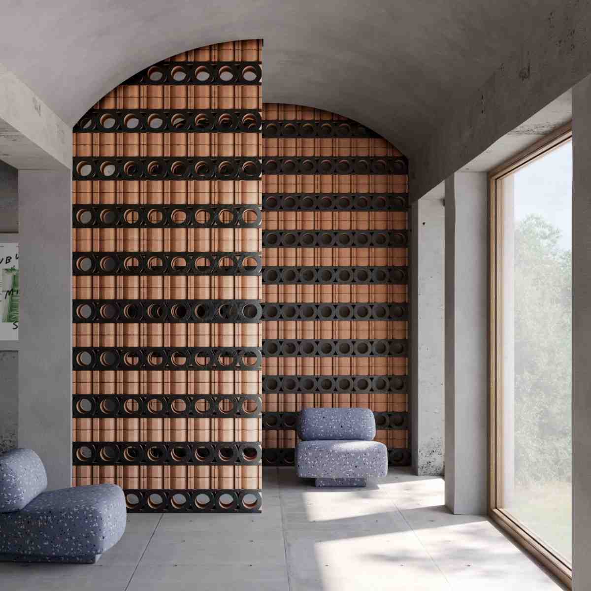 Mutina Jali 3D artisanal extruded terracotta modular screen wall with circular and rectangular openings in natural terracotta and nero tones installed as architectural partition in interior with concrete walls and arched doorway