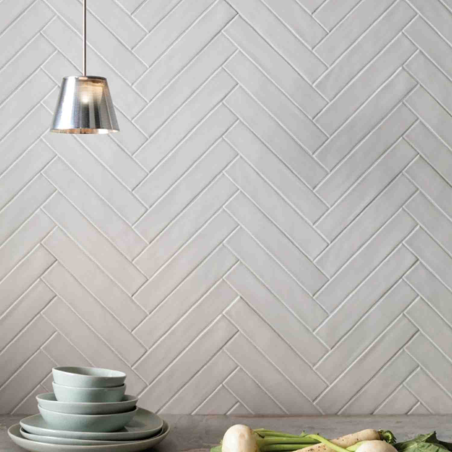 Ceramica Colli Kyushu bianco matte ceramic wall tiles installed in herringbone pattern with chrome pendant light fixture