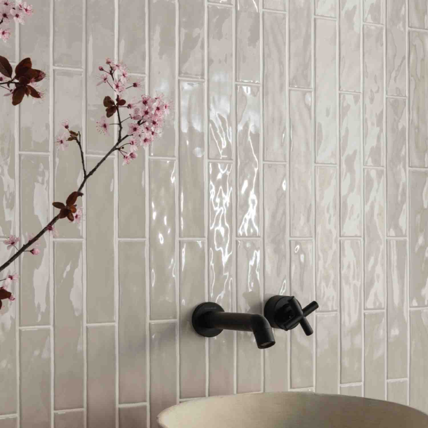 Ceramica Colli Kyushu grigio glossy ceramic wall tiles in horizontal stacked bond with cherry blossom branch decoration