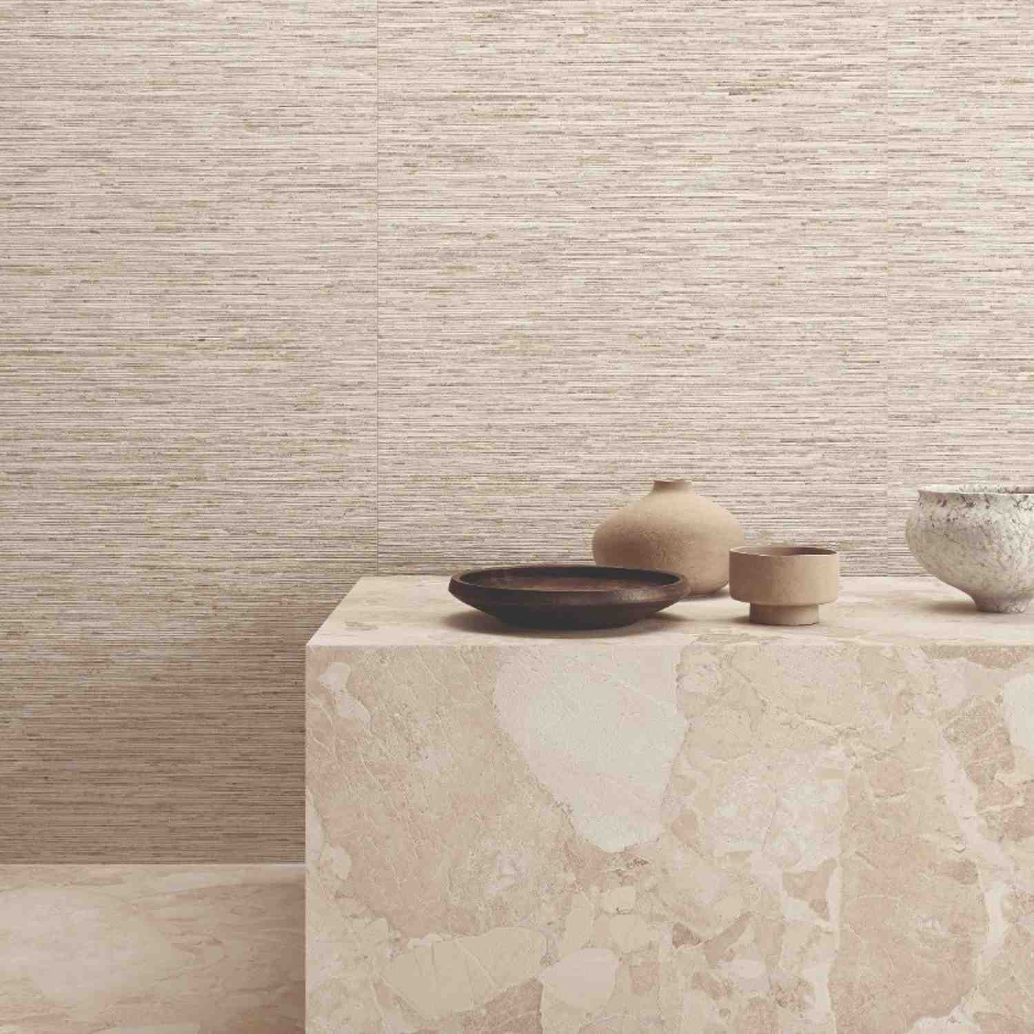 Ergon Matera Stone Ritmo Greige textured wall tiles with horizontal linear pattern, stone pedestal with artisan ceramic bowls and vase in neutral tones