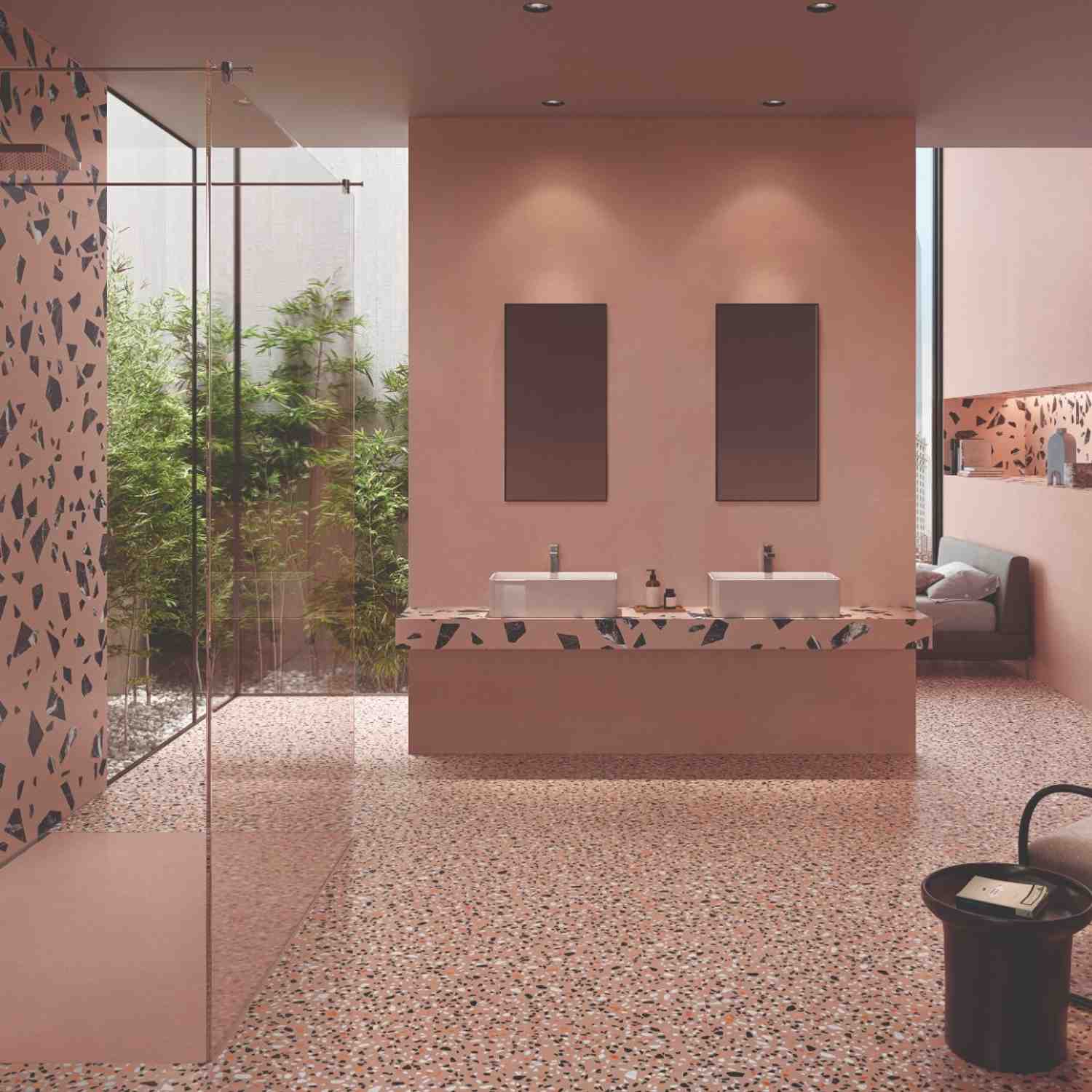 Emilceramica Medley Pink Minimal matte porcelain wall and Pop terrazzo-style floor tiles in a contemporary bathroom with dual vessel sinks, glass shower enclosure, indoor plants, and dark artwork panels