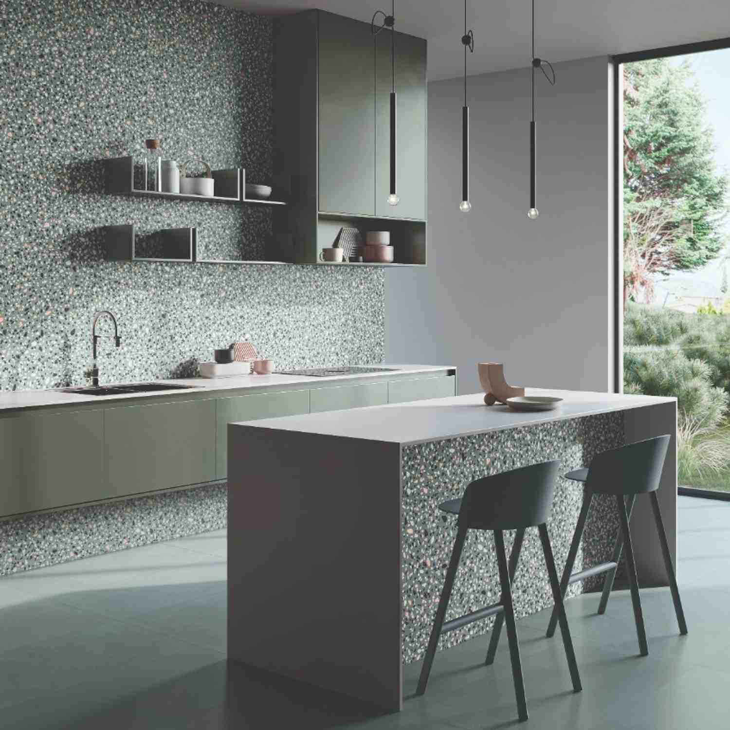 Emilceramica Medley Green Minimal Pop terrazzo-style porcelain wall tiles in a modern kitchen with dark green cabinetry, open shelving, pendant lights, white countertop island with bar stools, and large garden window