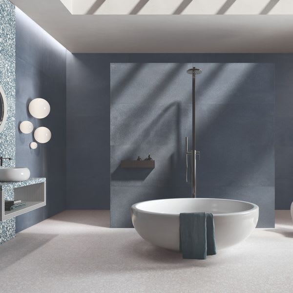 Emilceramica Medley Blue Minimal matte porcelain wall tiles in a modern bathroom with white freestanding bathtub, rain shower, round wall sconces, and Grey Minimal floor tiles