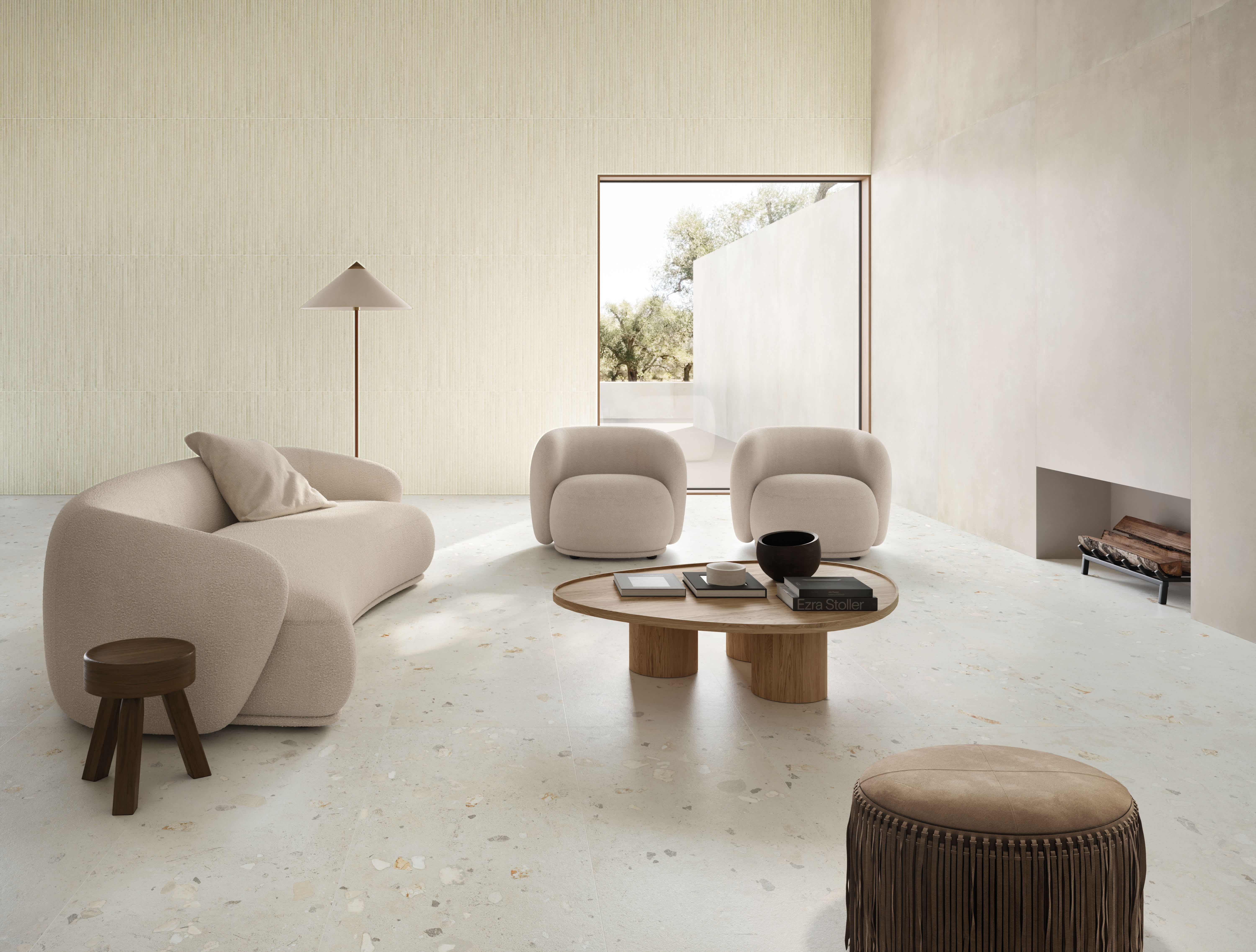 Living room with smooth white I Cementi porcelain slab walls and fireplace, a finely ribbed cream feature wall, bouclé sofa and armchairs.