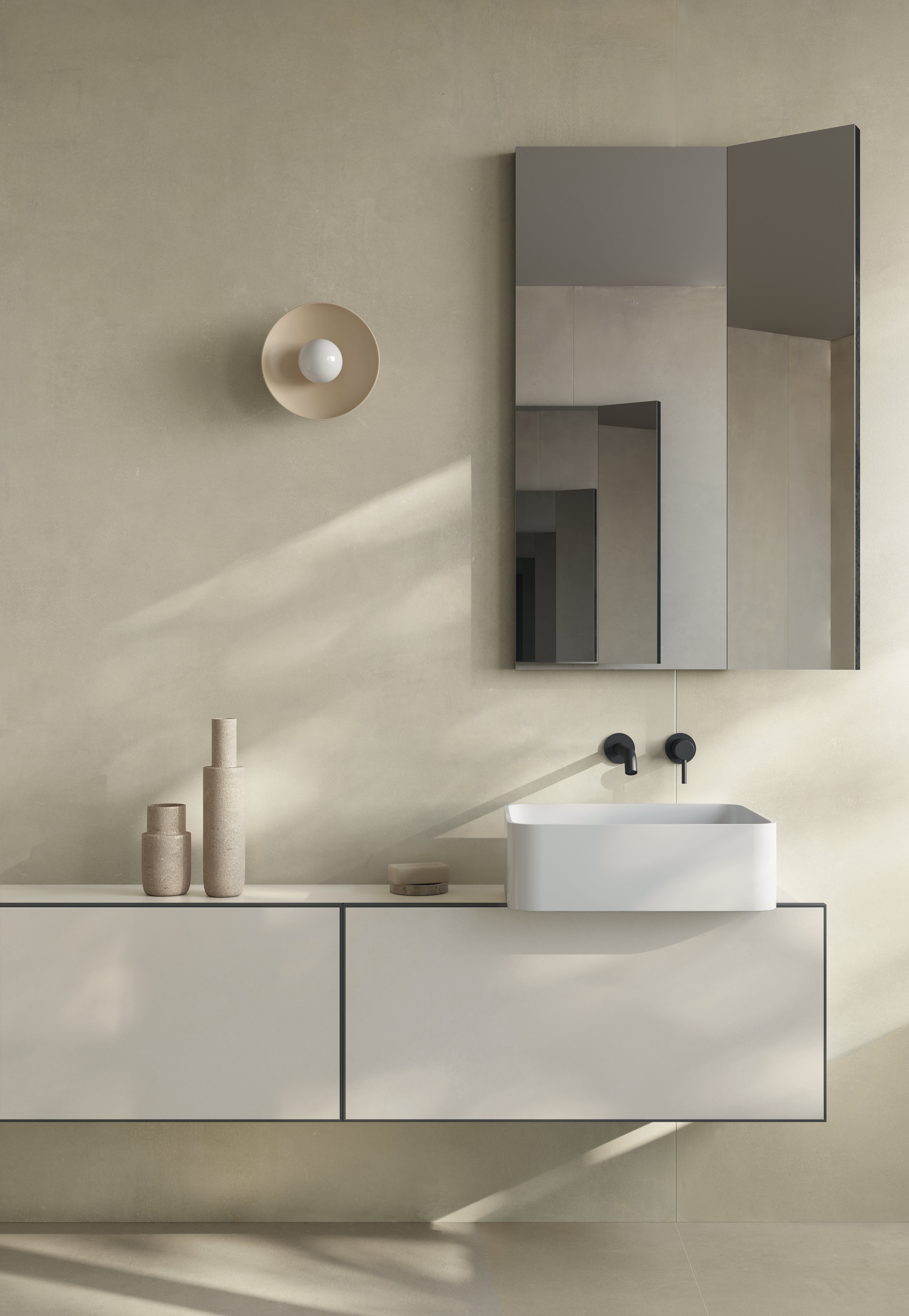 Soft beige I Cementi porcelain slab wall behind a floating white vanity, a round wall light and a tall mirror cabinet.