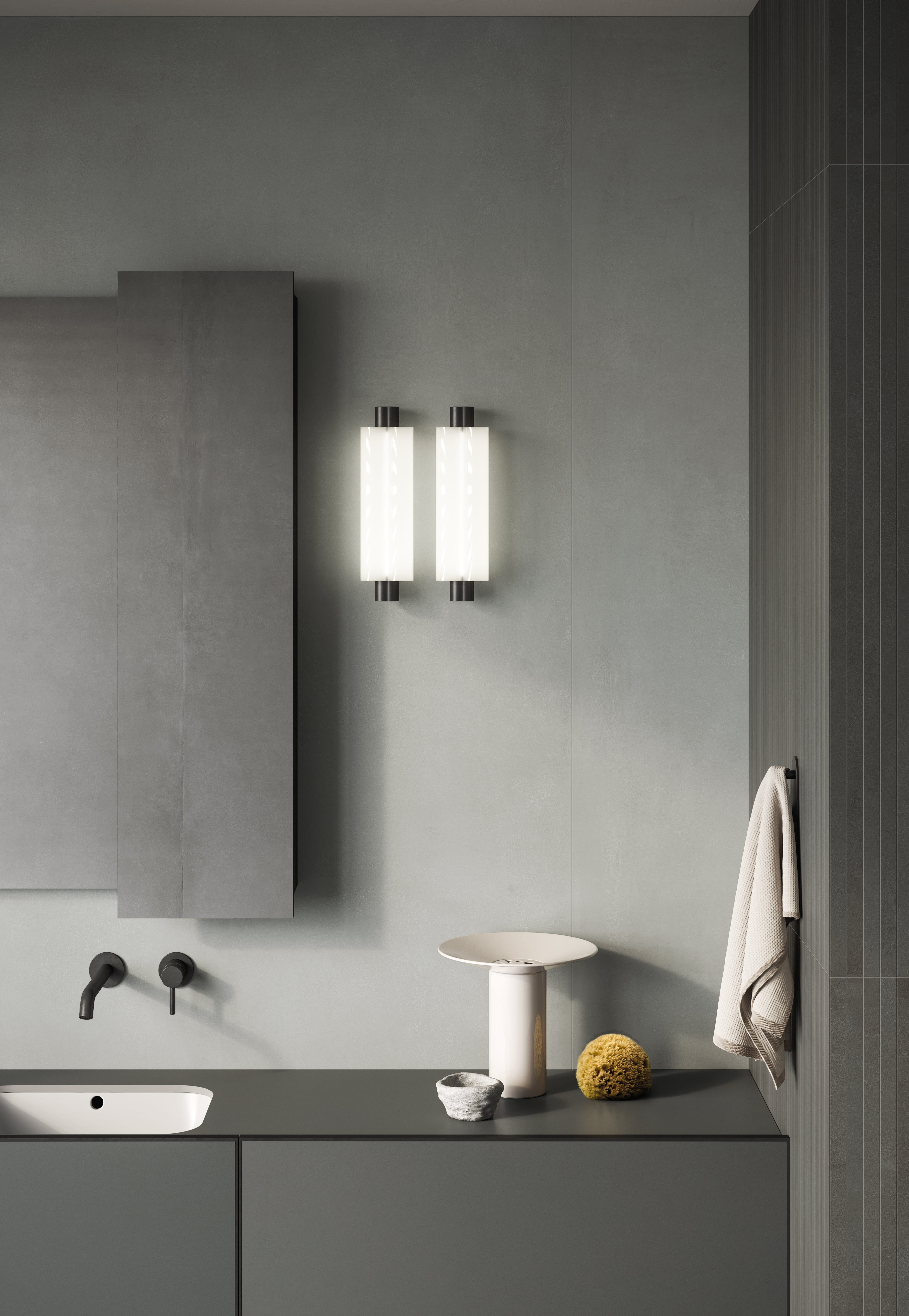Grey I Cementi porcelain slab bathroom wall beside a ribbed charcoal panel, with twin glass wall lights, a mirror cabinet and dark vanity.