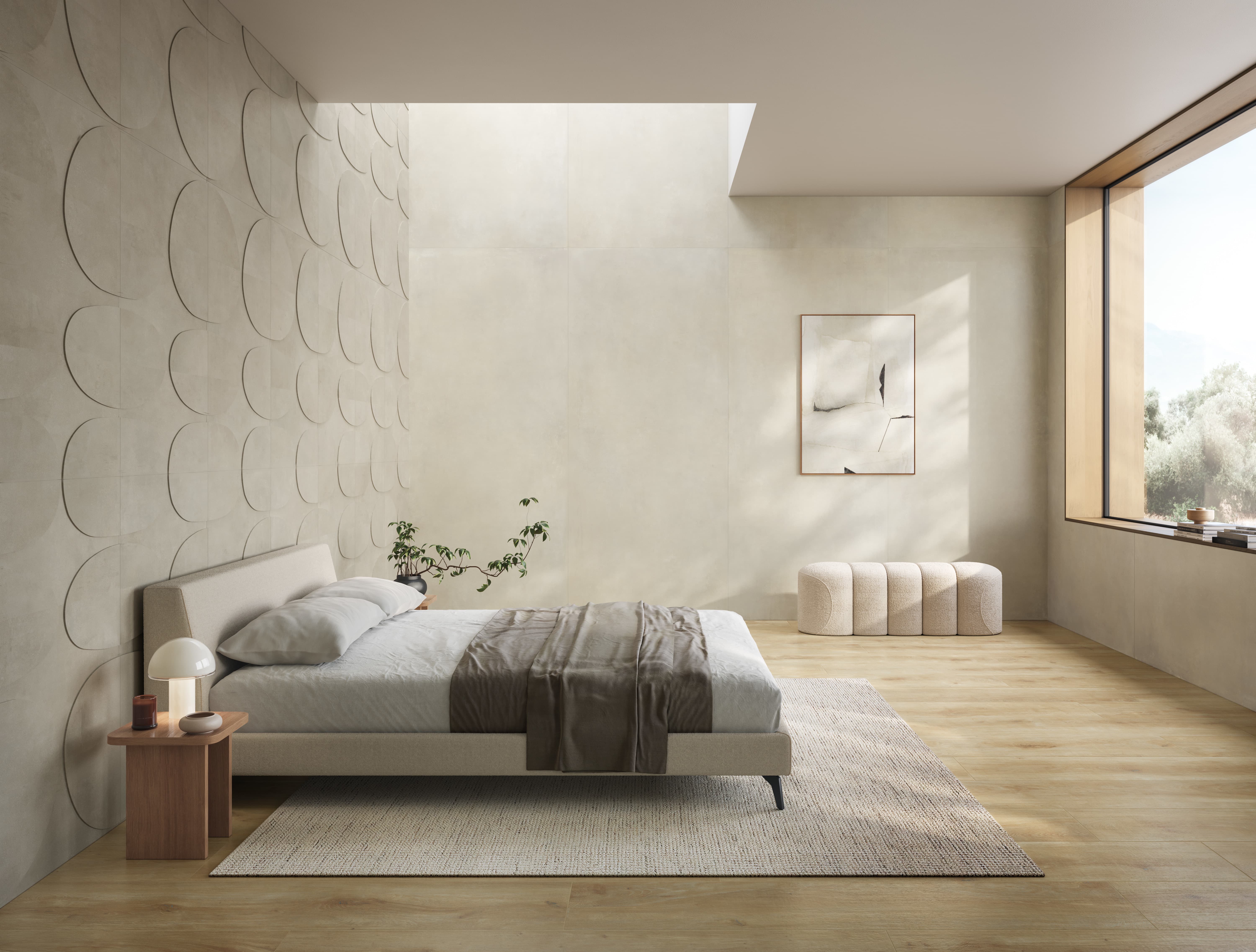Bedroom with warm beige I Cementi porcelain slab walls beside a sculpted relief wall, a low bed, rug and light wood floor.