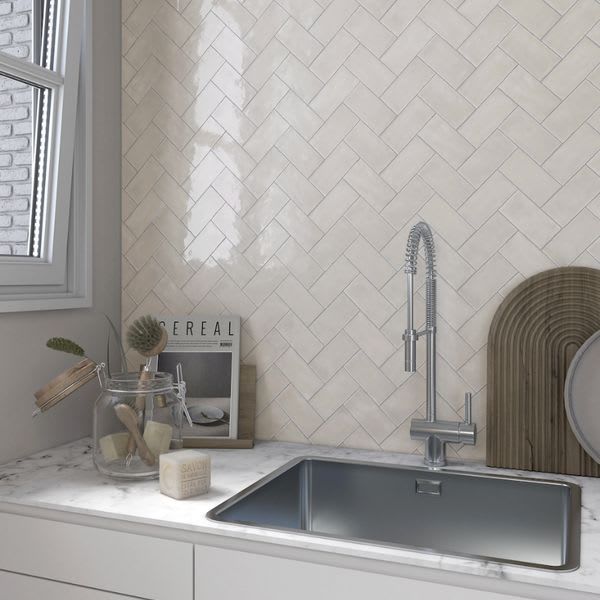 Terratinta Memorie Bianco Antico white glossy ceramic tiles in herringbone kitchen backsplash thumbnail with stainless steel sink and chrome faucet