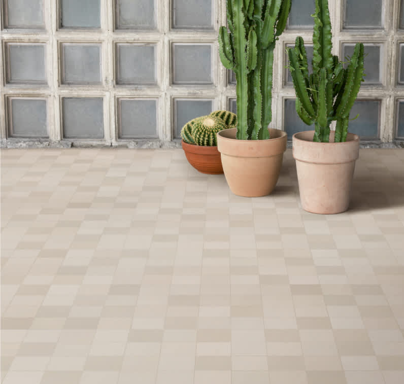 Mutina Mews Chalk light beige matte porcelain floor tiles in checkerboard pattern with terracotta pots and cacti against light blue tiled wall