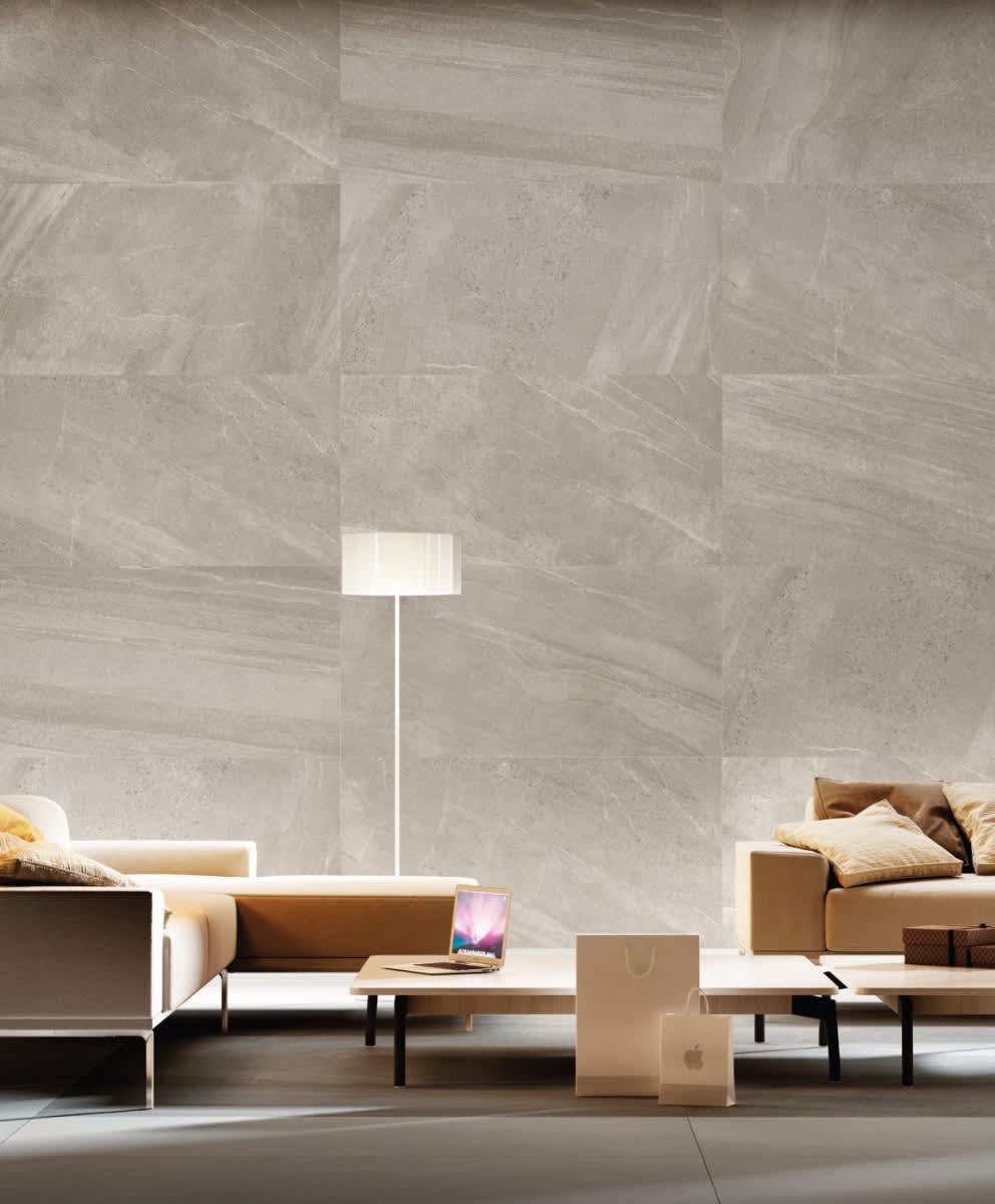 Impronta Nordic Stone Danimarca mosaic large format porcelain wall tiles in warm beige taupe tones with natural stone veining and white floor lamp in a living space
