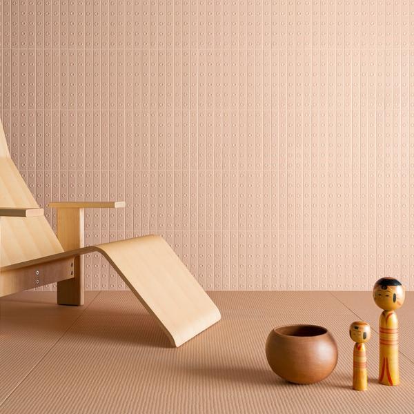 Mutina Punto glazed ceramic wall tiles in Rose pink with raised dot pattern, wooden lounge chair and decorative wooden objects