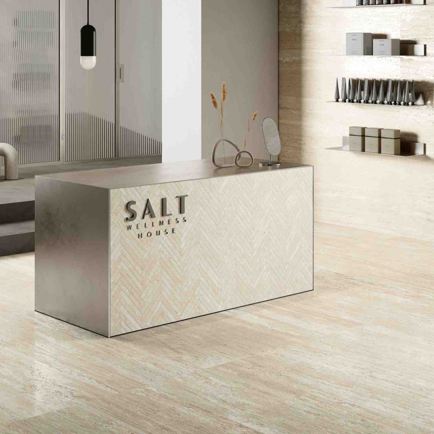 Ceramica Fioranese Senzatempo Trav porcelain stoneware tiles in Beige travertine-look on reception desk and floor in modern wellness spa setting with product display shelves and reeded glass partition