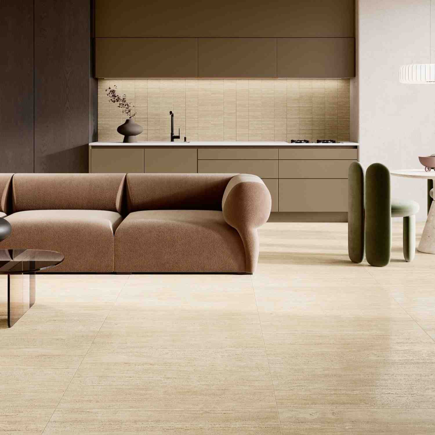 Ceramica Fioranese Senzatempo Trav porcelain stoneware tiles in Beige travertine-look as kitchen backsplash with horizontal linear pattern, dark wood upper cabinetry, matte olive lower cabinets, curved tan sofa, and green accent chair in open-plan contemp