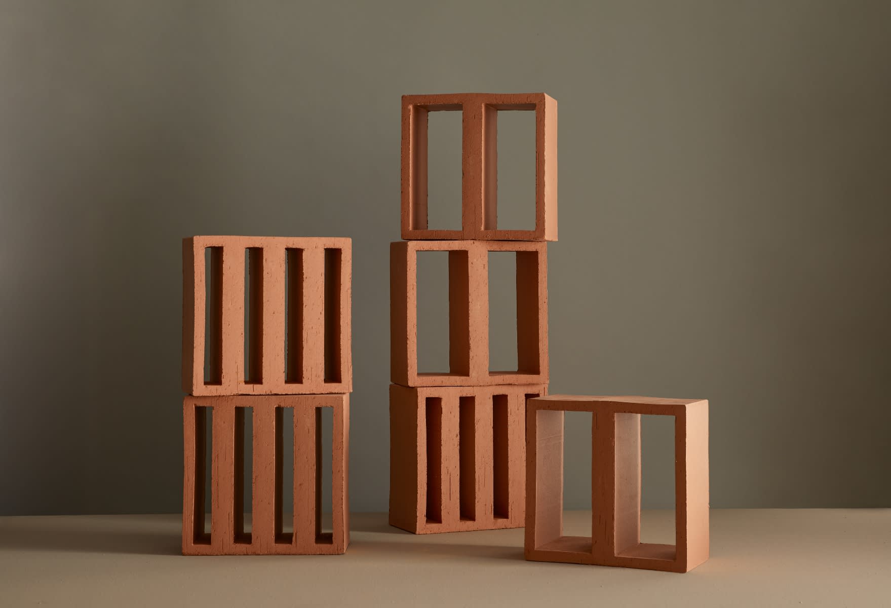 Mutina Tally Narrow and Wide extruded terracotta modules artistically stacked showing both format variations with vertical slot and rectangular openings in natural Argilla matte finish