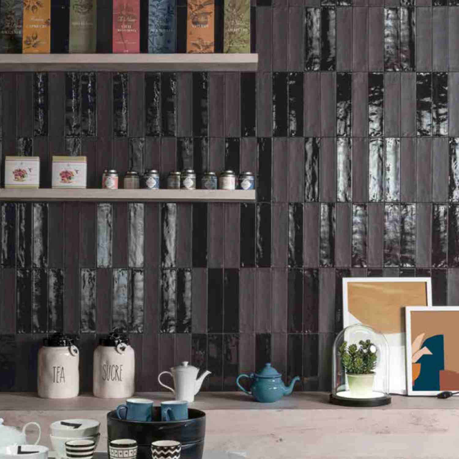Ergon Total Brick glazed ceramic wall tiles in dark charcoal as kitchen backsplash with wooden open shelving, vintage canisters, and blue ceramic dishware