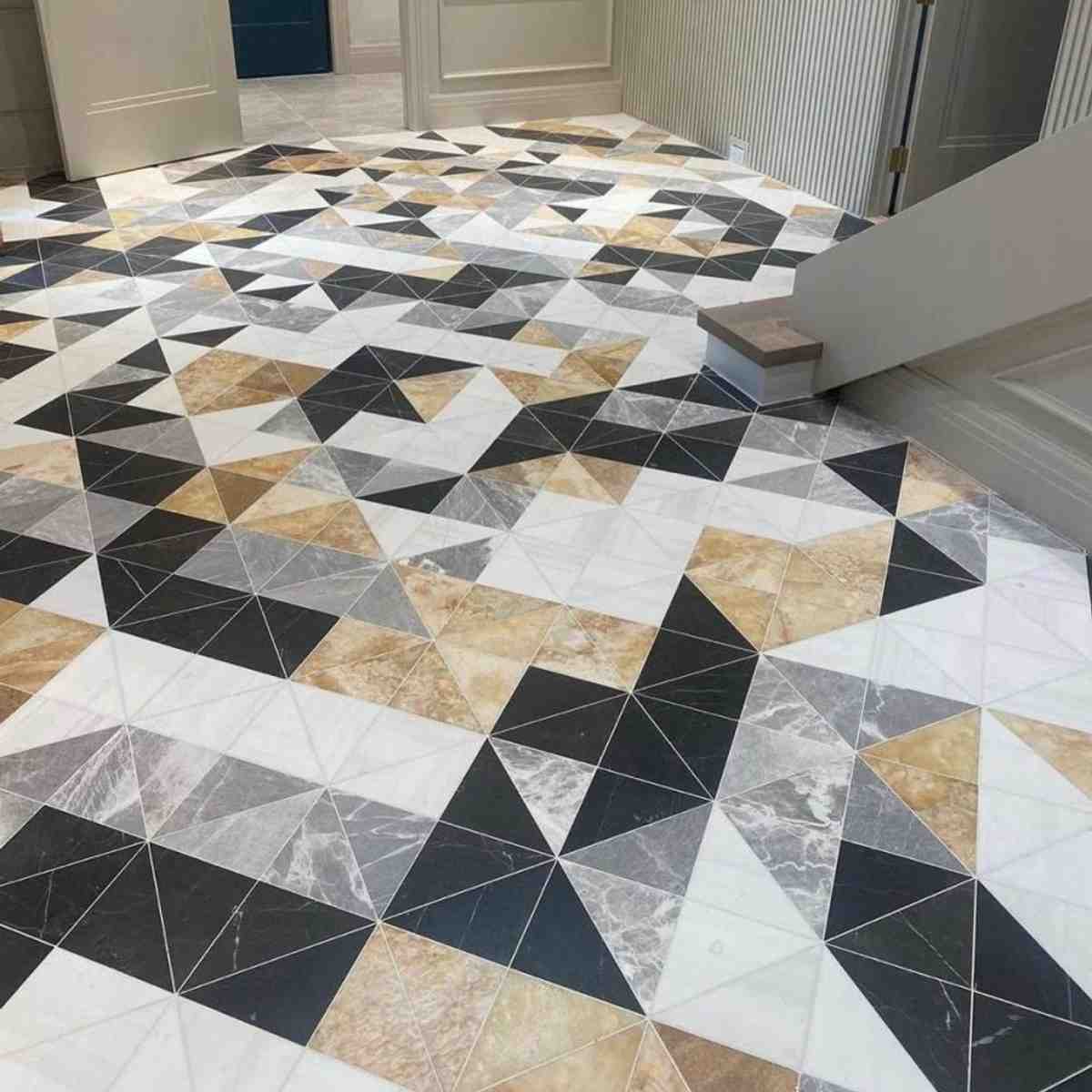 Triangle Marble multi-colored geometric triangle pattern marble tile in black, white, gold, and gray installed as foyer flooring
